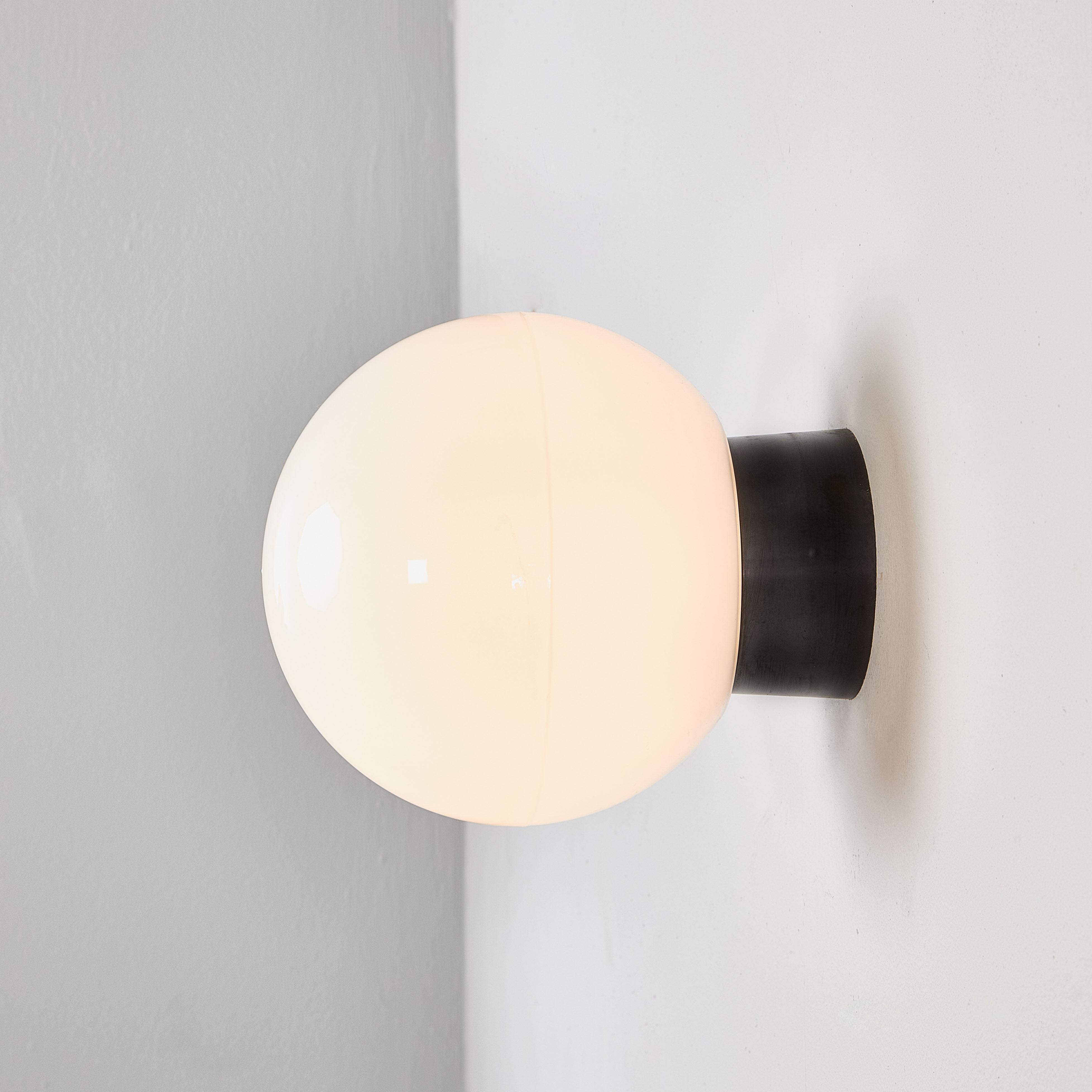 1950's New Old Stock Opaque Globe Wall Lamp - Large Quantity Available. 

The wall mount tops are original Bakelite (self insulated) and simply screw into the glass globe. Each lamp has been cleaned and restored. Given the unique nature of the