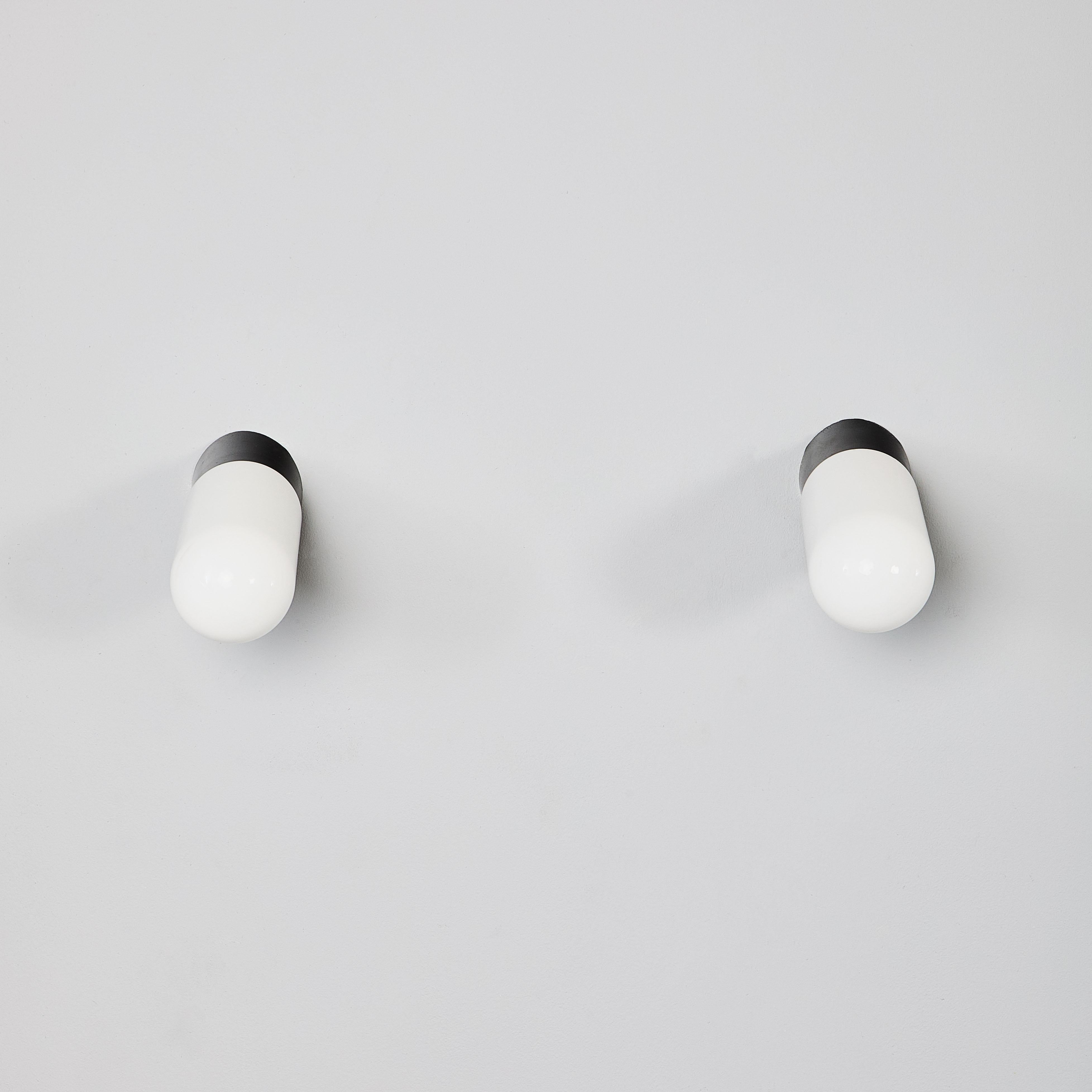 1950's New Old Stock Opaque Lozenge Wall Lamp - Large Quantity Available. 

The wall mount tops are original Bakelite (self insulated) and simply screw into the glass orb. Each lamp has been cleaned and restored. Given the unique nature of the