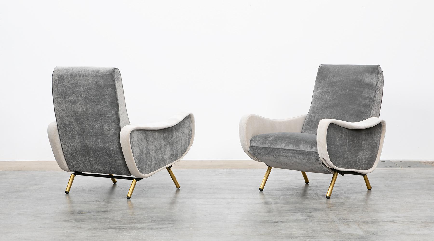 This beautiful couple of lounge chairs designed by Marco Zanuso comes on four brass legs. The seat and the back of the chairs are covered with two different tones in grey and high-quality fabric.
The chairs provide exquisitely comfortable seating