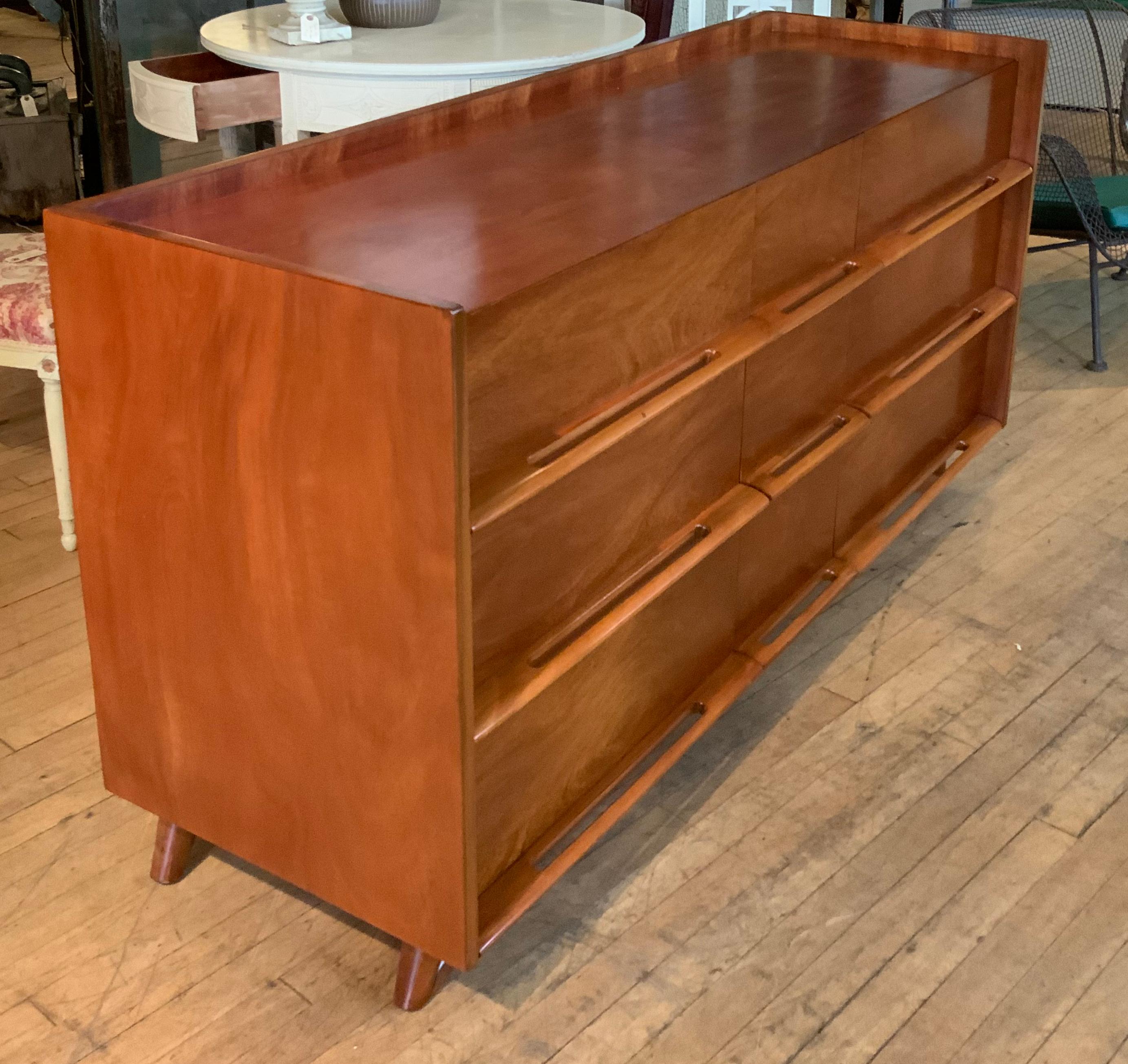 A beautiful large nine drawer 1950's chest, in nicely figured mahogany. Handsome design with the drawer pulls integrated into the extension at the base of each drawer, in the manner of Edmund Spence. beautifully refinished.
