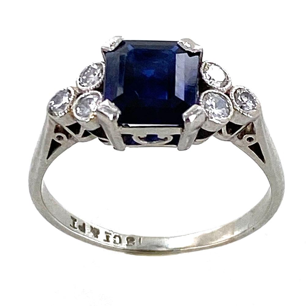 Gorgeous estate sapphire diamond ring circa 1950's. The 1.63 carat blue sapphire has not been treated or enhanced, and comes with a certificate from the AGL. The rectangular emerald cut sapphire is adorned with six round brilliant cut diamonds