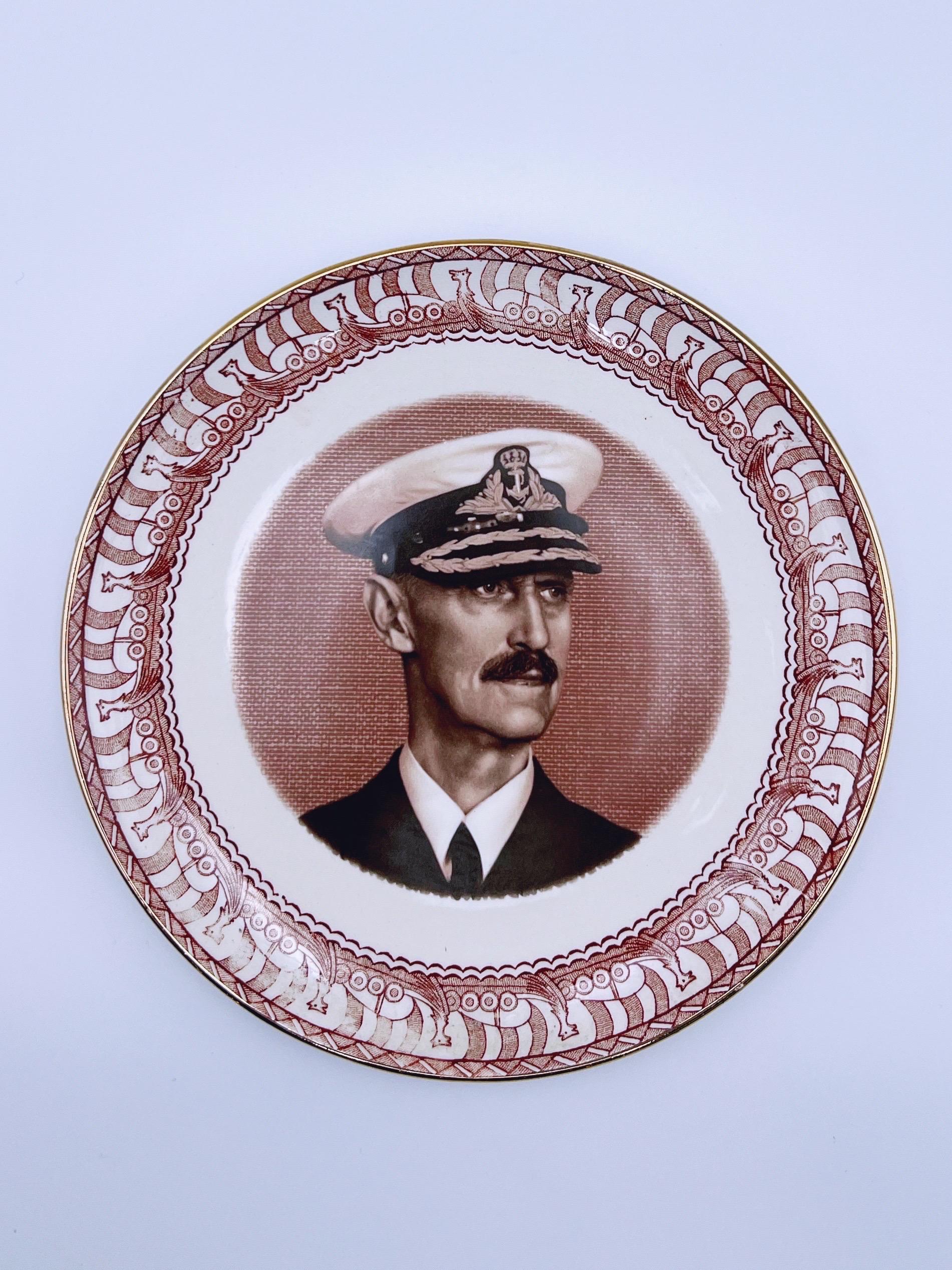 Vintage wall-hanging plate / commemorative plate from the 1950s featuring a portrait of Norwegian King Haakon VII (1872-1957) in the center, surrounded by a Scandinavian Viking ship pattern. 

Produced by Egersund Faience, Norway. The stamp was in