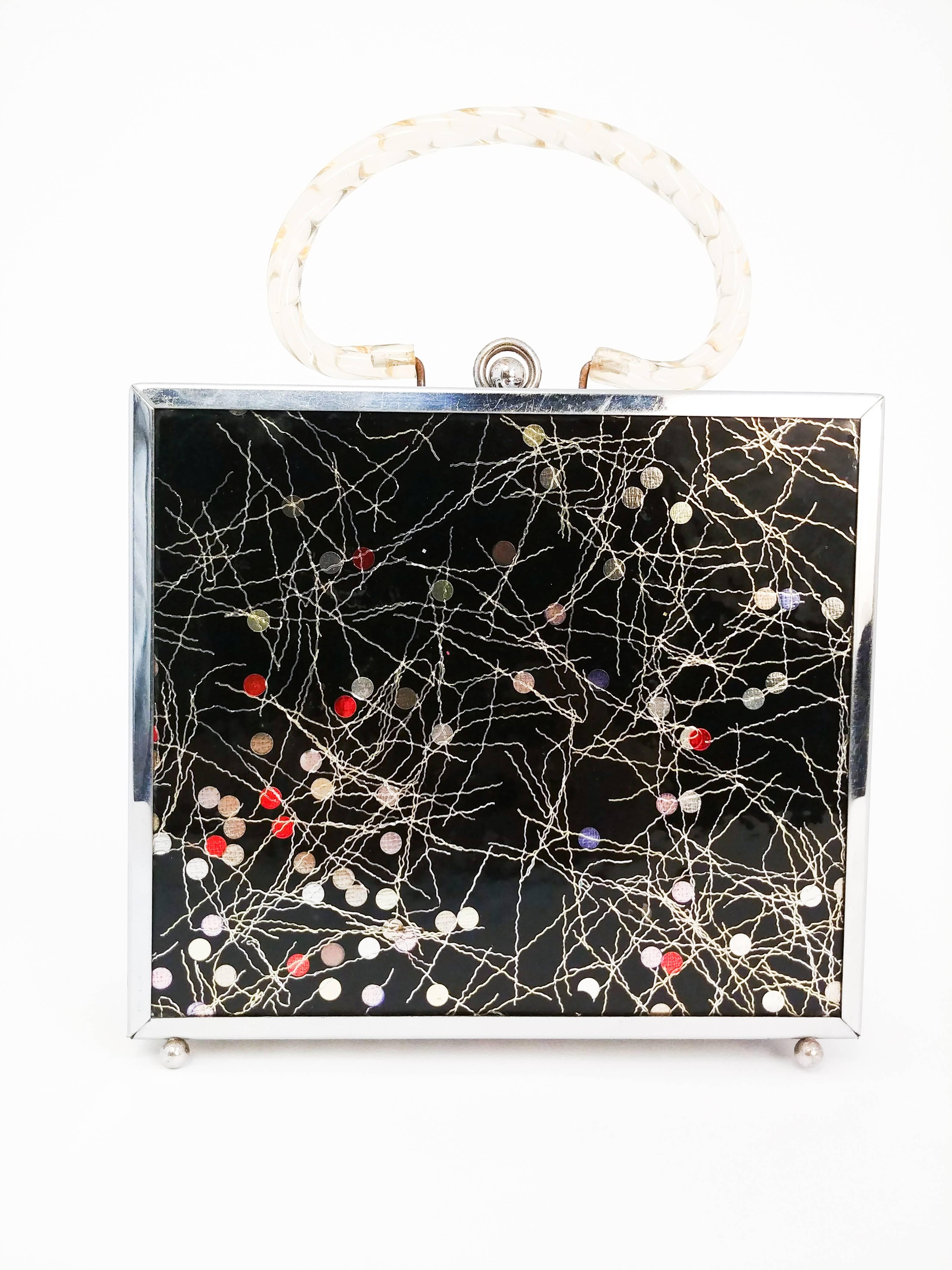 1950s Novelty Metal Purse w/ Lucite Handles. Early plastic front and back with abstract dot and line details, metal sides with cutouts, and metal feet. Lucite handles, printed lining with clean interior. 