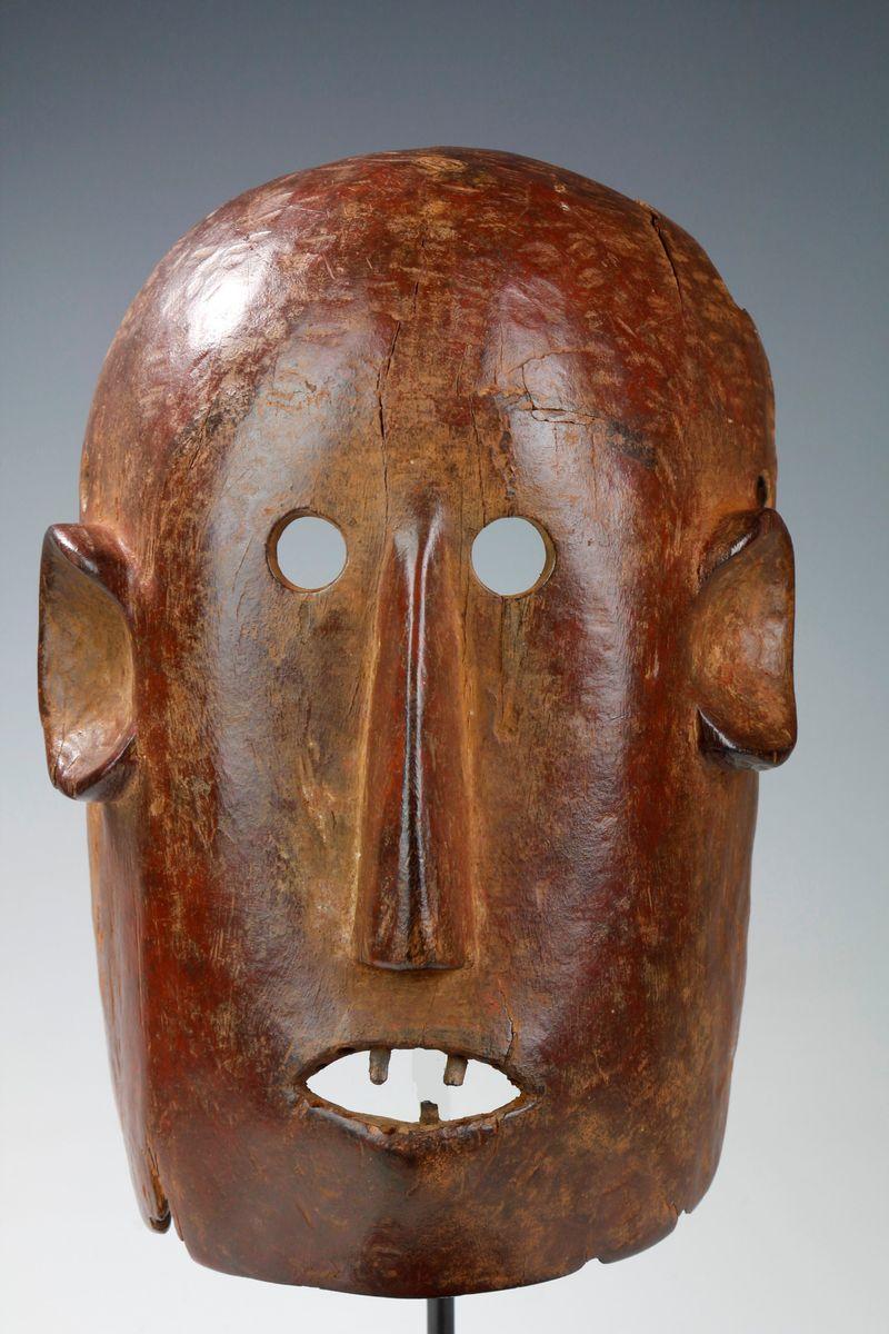 This finely carved Nyamwezi mask displays a powerful facial expression, with small rounded eyes and large ears, a long and slender nose, and an open mouth with inserted wooden teeth.

Carved from a dense wood, the surface of the mask has been