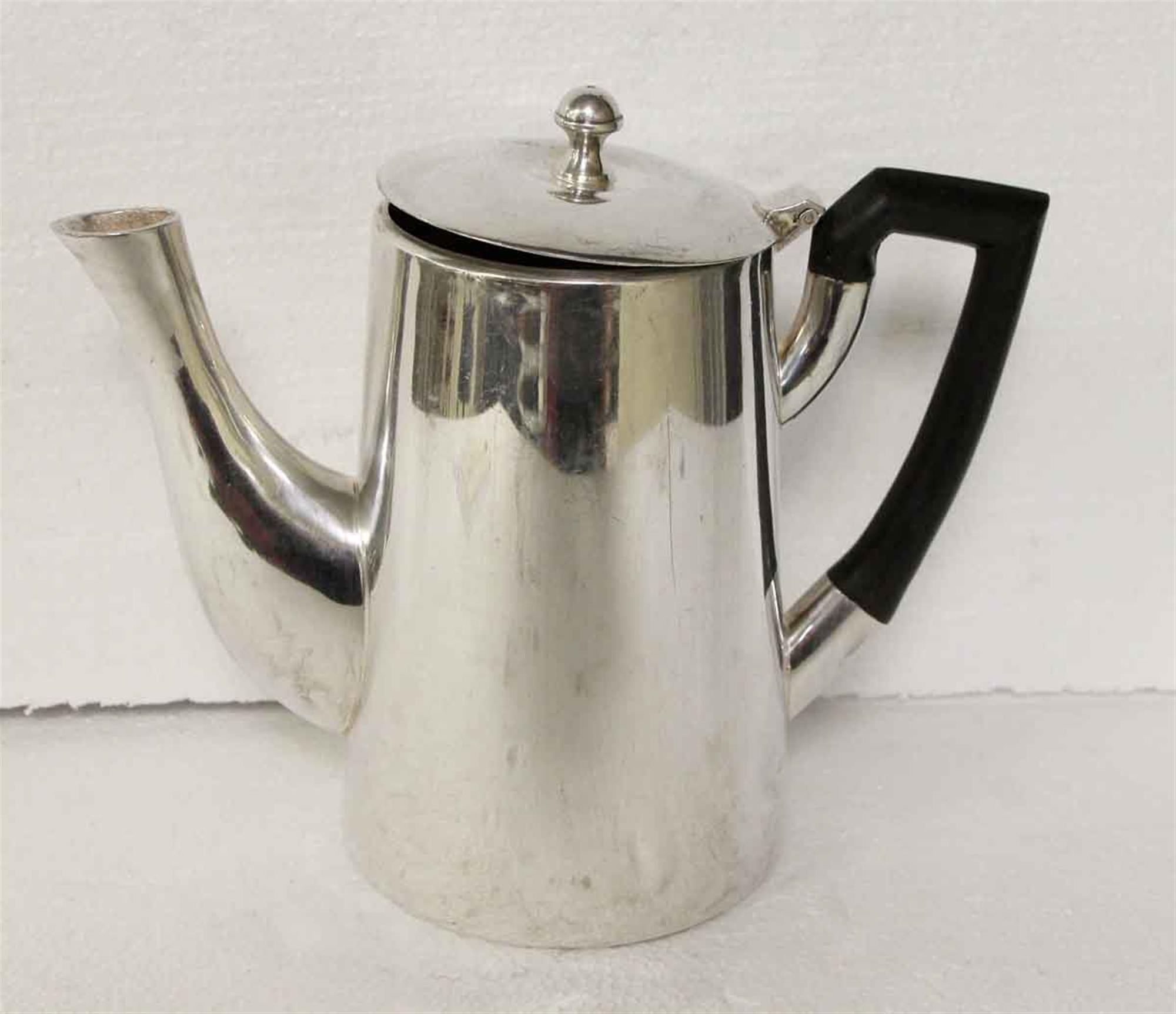 1950s silver plated tea pot with lid and black handle done in a Mid-Century Modern style. Each pot shows wear from use in the hotel. Waldorf Astoria authenticity card included with your purchase. Small quantity available at time of posting. Please