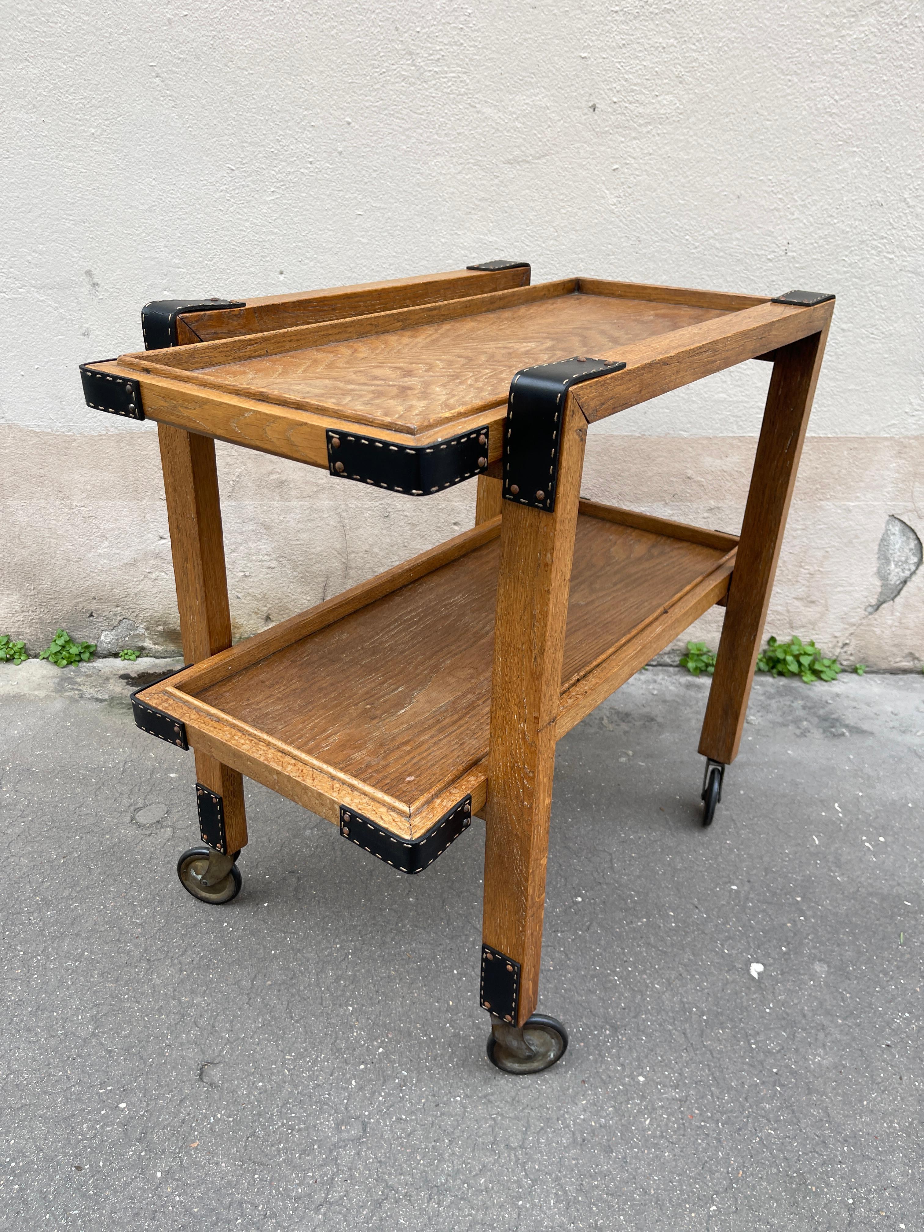 1950's Stitched leather and oak bar cart by Jacques Adnet
France
Small trace of water / could be re-finished if needed
Great overall vintage condition
