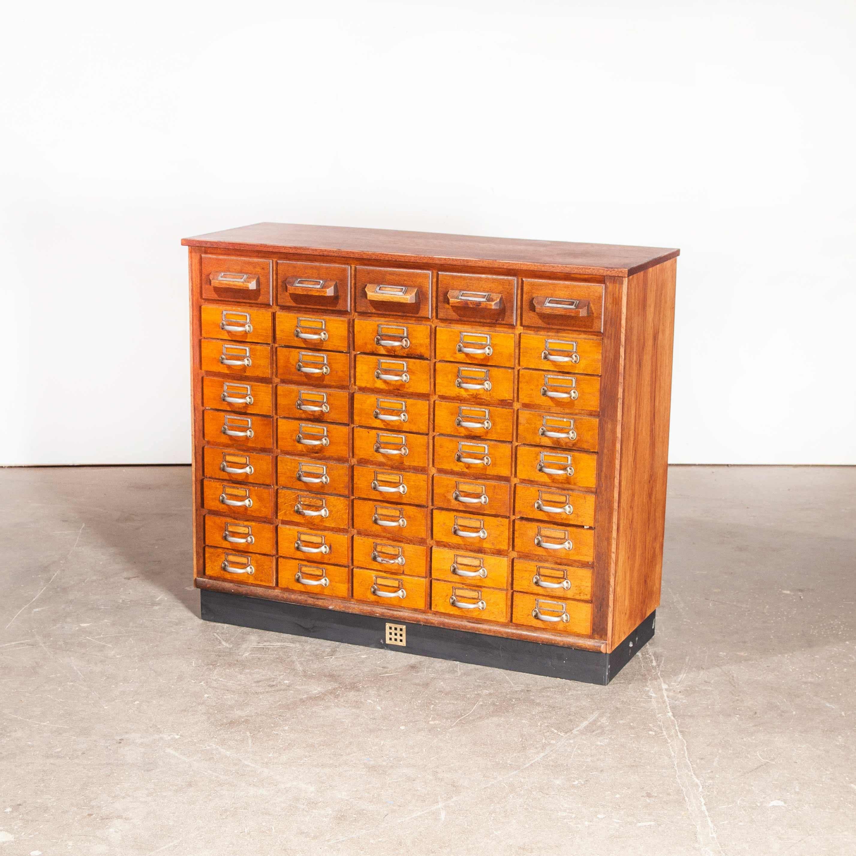 1950s oak apothecary multi drawer chest of drawers, forty five drawers. The chest of drawers has a paneled back, and boasts interchangeable dividers in some of the drawers. The tongue and groove drawers are also numbered which is a unique touch.