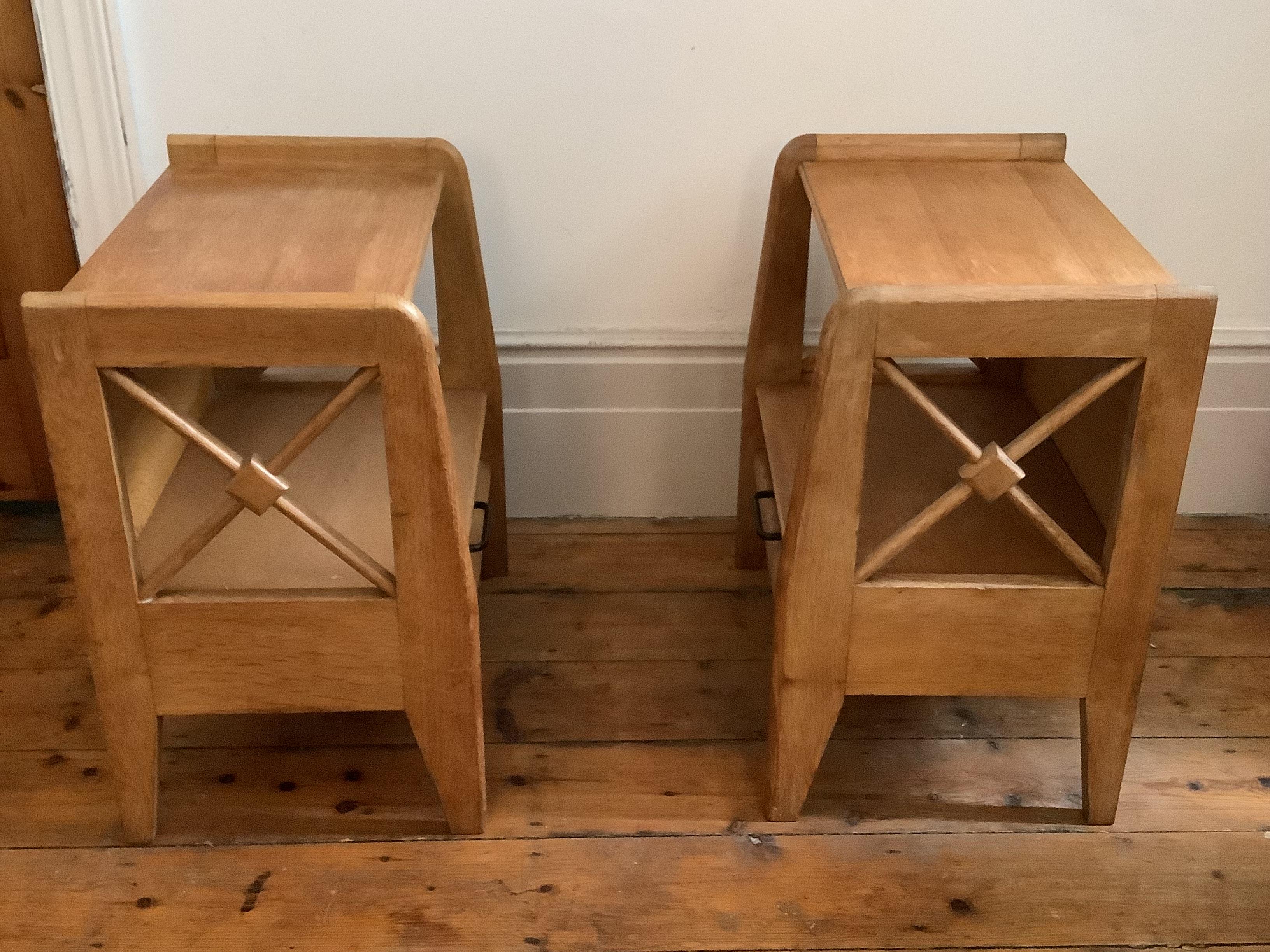 
A pair of modernist Art Deco oak nightstands by renowned French designer Jacques Adnet (1900-1984) created in the 1930's. The open, geometric, cross-shaped cut outs on the sides and the raised edges along the top give this piece an architectural
