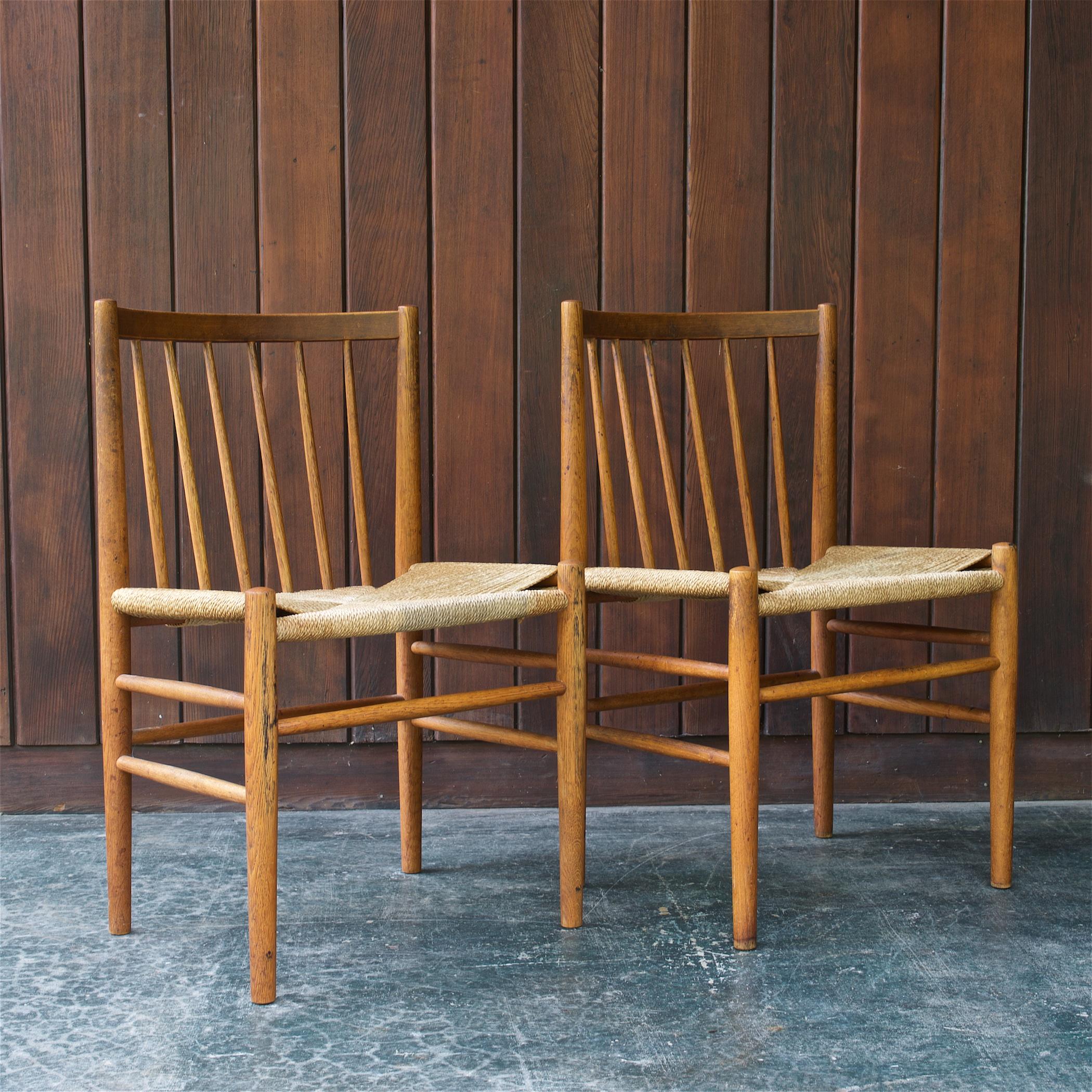 A rare and wonderful pair of reinvented shaker spindle backed chairs with rush woven seats by FDB Møbler. Just very well used, no breaks to the corded seats, and no looseness to frames. 

Usable, Strong ad Sturdy Chairs, just soiled rush seats, and