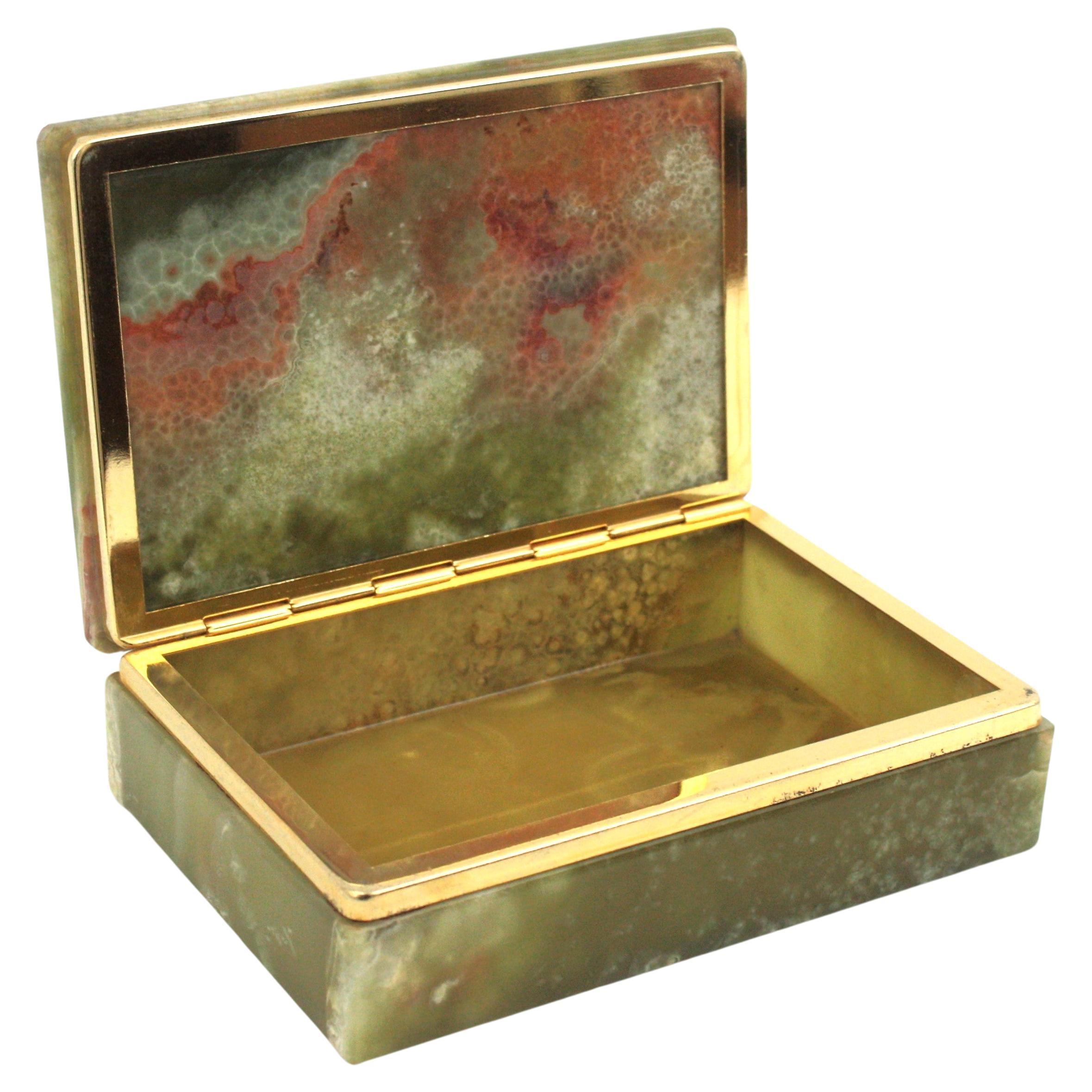 Mid-Century Modern hinged box veneered in fine Onyx stone, Spain, 1950s.
This exquisite vintage 1950s rectangular box is all constructed with onyx and features a brass hinge.
This trinket box shows beautiful eye-catching veins and bandings and it is