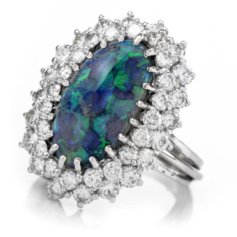 This cosmic opal and diamond ring is crafted in 14-karat white gold, weighing 8.4 grams and measuring 25mm x 12mm high. Showcasing a prominent oval shaped, prong-set opal weighing approximately 3.83 carats. Surrounded by a double halo of 40