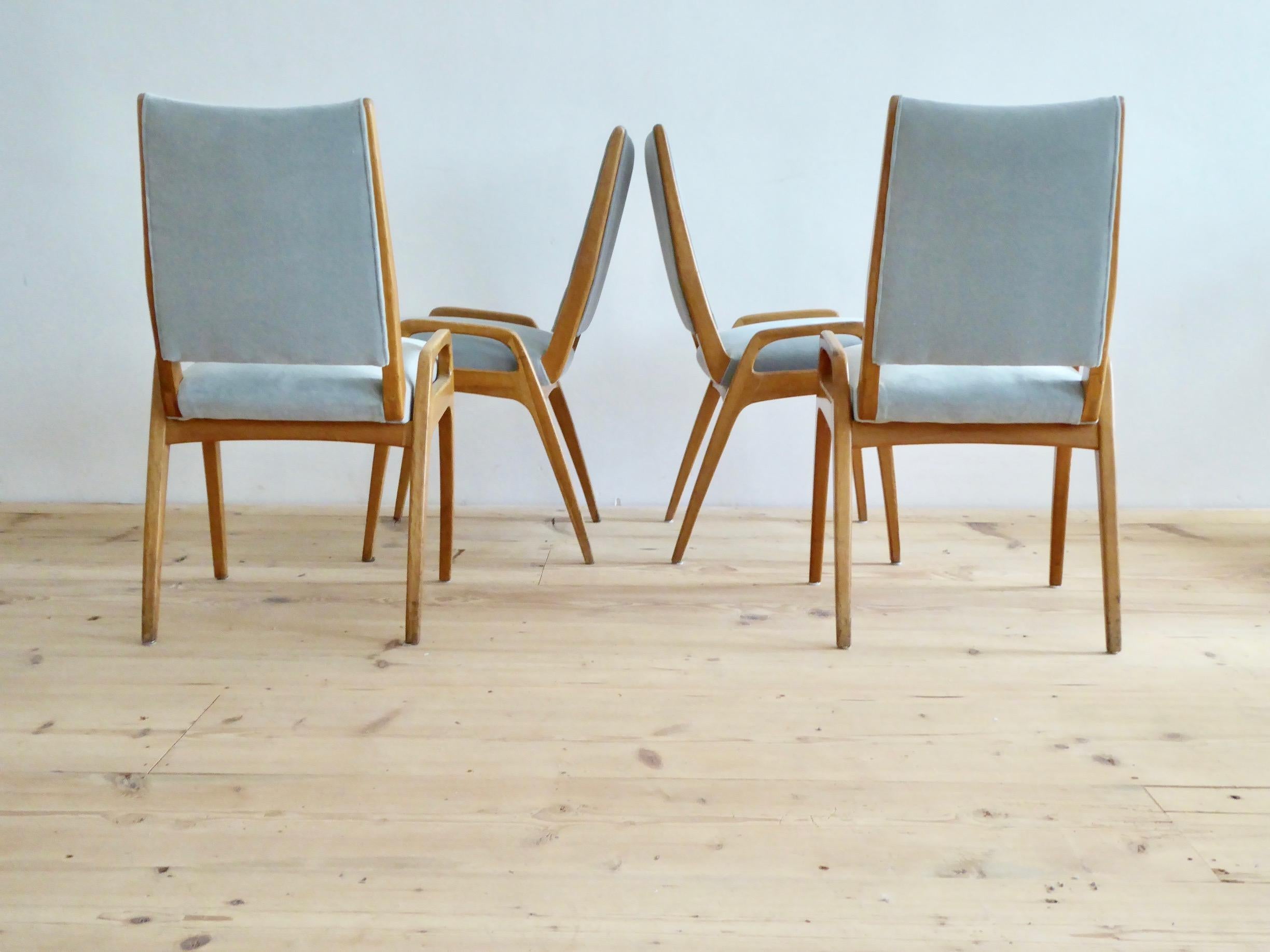 Set of four elegant dining room chairs with a frame of massive walnut. They are newly upholstered with a high quality velvet fabric in light grey to underline their fresh character and Fine attitude.
To show the chairs historical integrity, we left