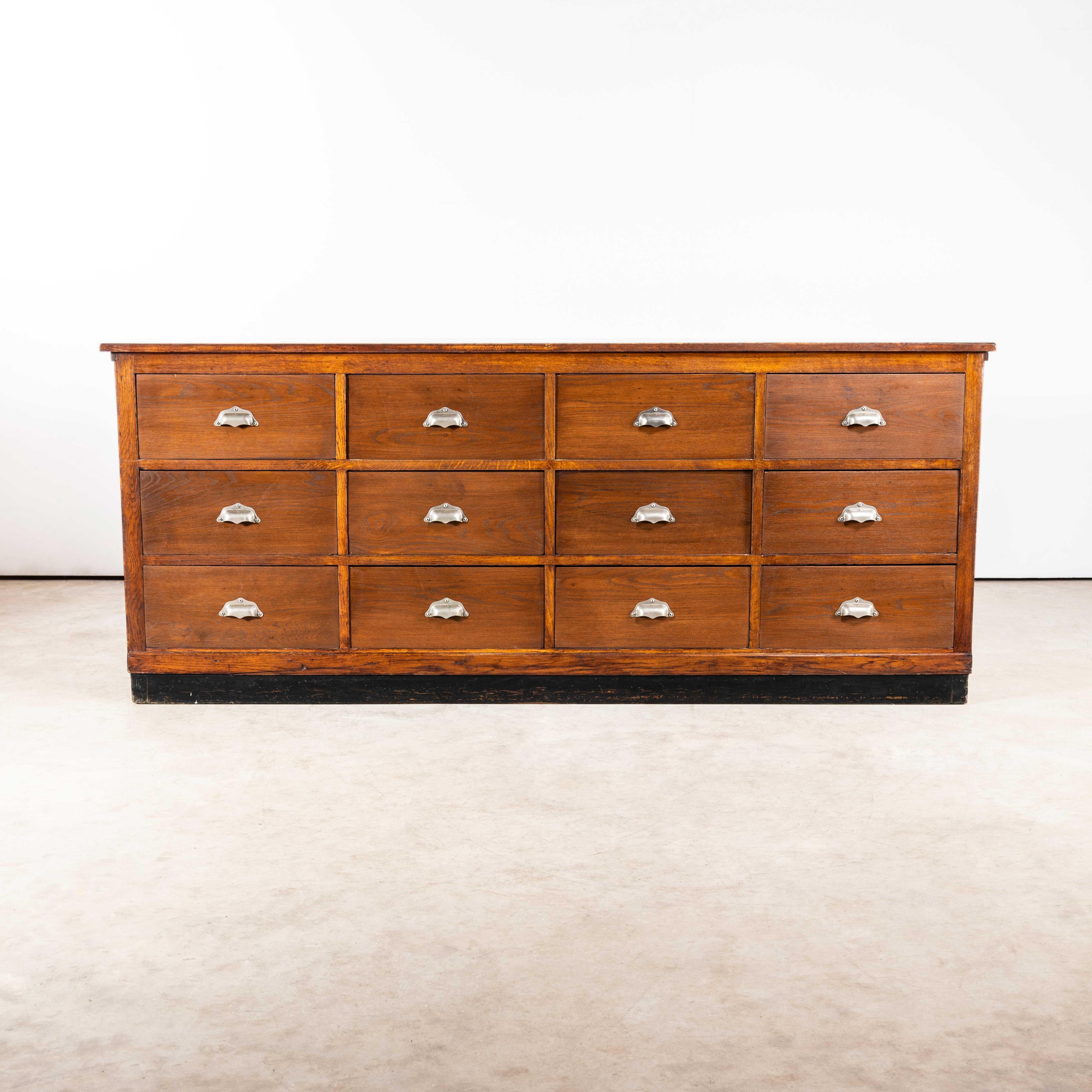 1950's Original French Apothecary Bank Of Drawers - Twelve Drawers. 
Good honest set of French drawers made in pitch pine with a solid oak top. The drawers were probably apothecary drawers as the three visible sides were well panelled and the