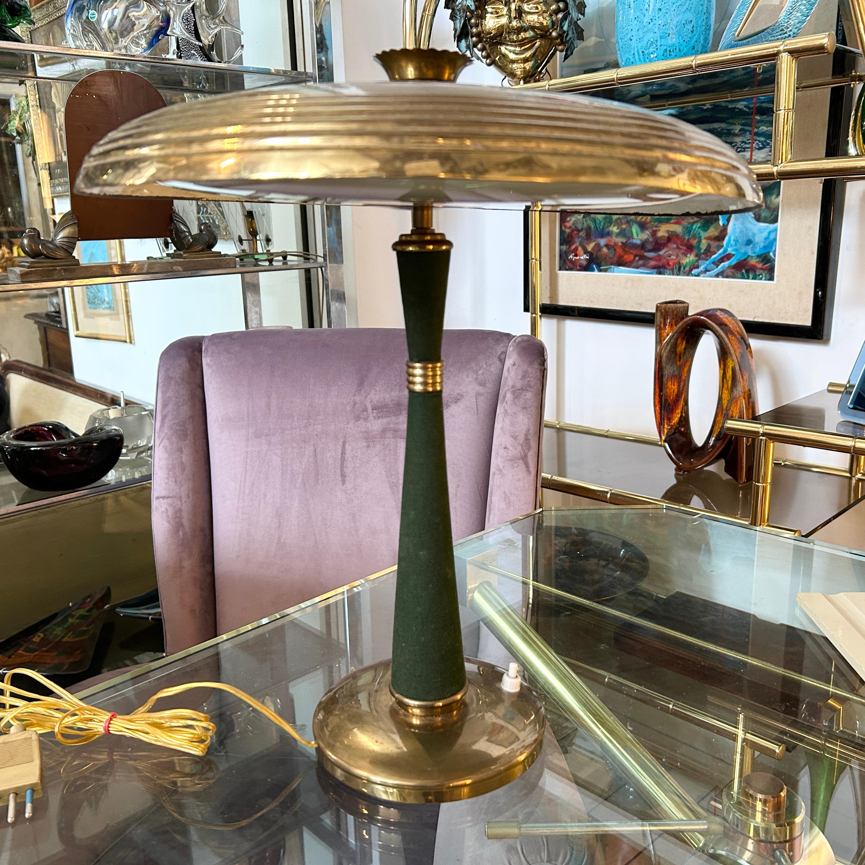 A table lamp designed and manufactured in Italy in the Fifties, it's in working order, brass in original patina, good conditions overall. This 1950s Mid-Century Modern brass and green fabric table lamp model 338 is a vintage lighting fixture that