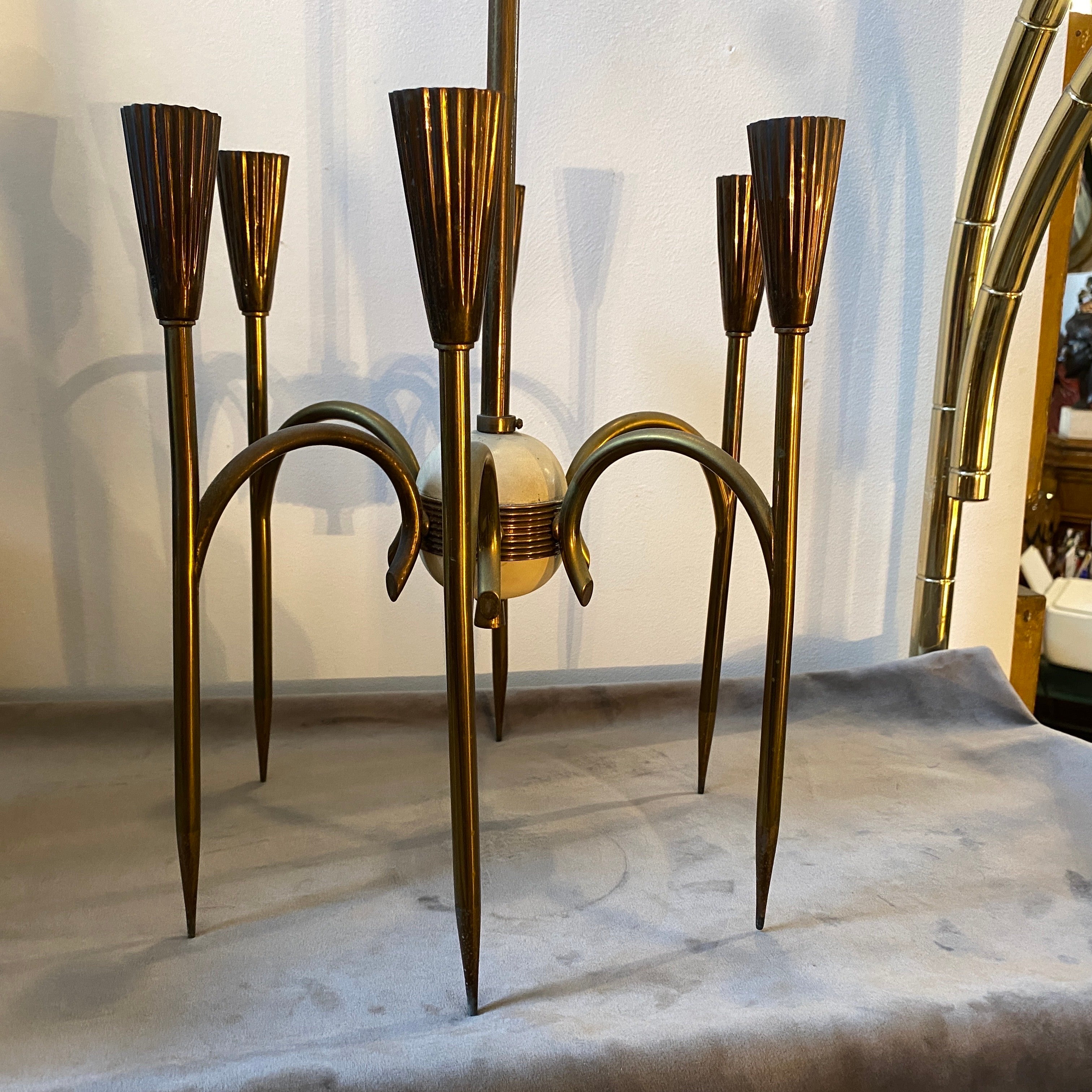 An elegant Mid-Century Modern brass chandelier designed and manufactured in Italy in the Fifties. High quality solid brass and the cleanliness of its line remembers design of Oscar Torlasco. It works both 110-240 volts and needs six regular e14