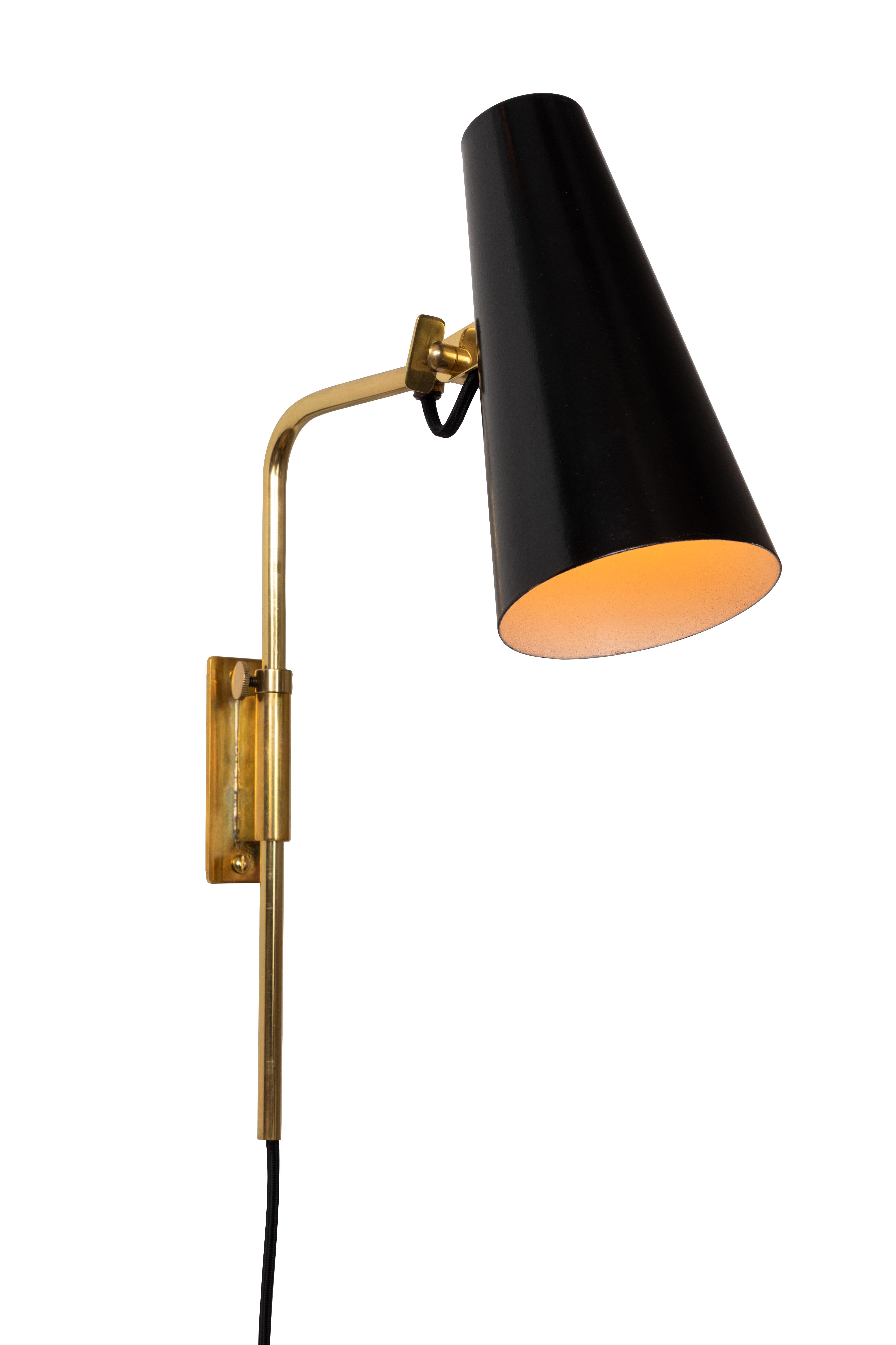 1950s Paavo Tynell 9459 wall lights for Taito OY. These rare and exceptionally refined wall lights are executed in black painted metal with attractively patinated brass armature and hardware. Signed with impressed manufacturer's mark to shade of