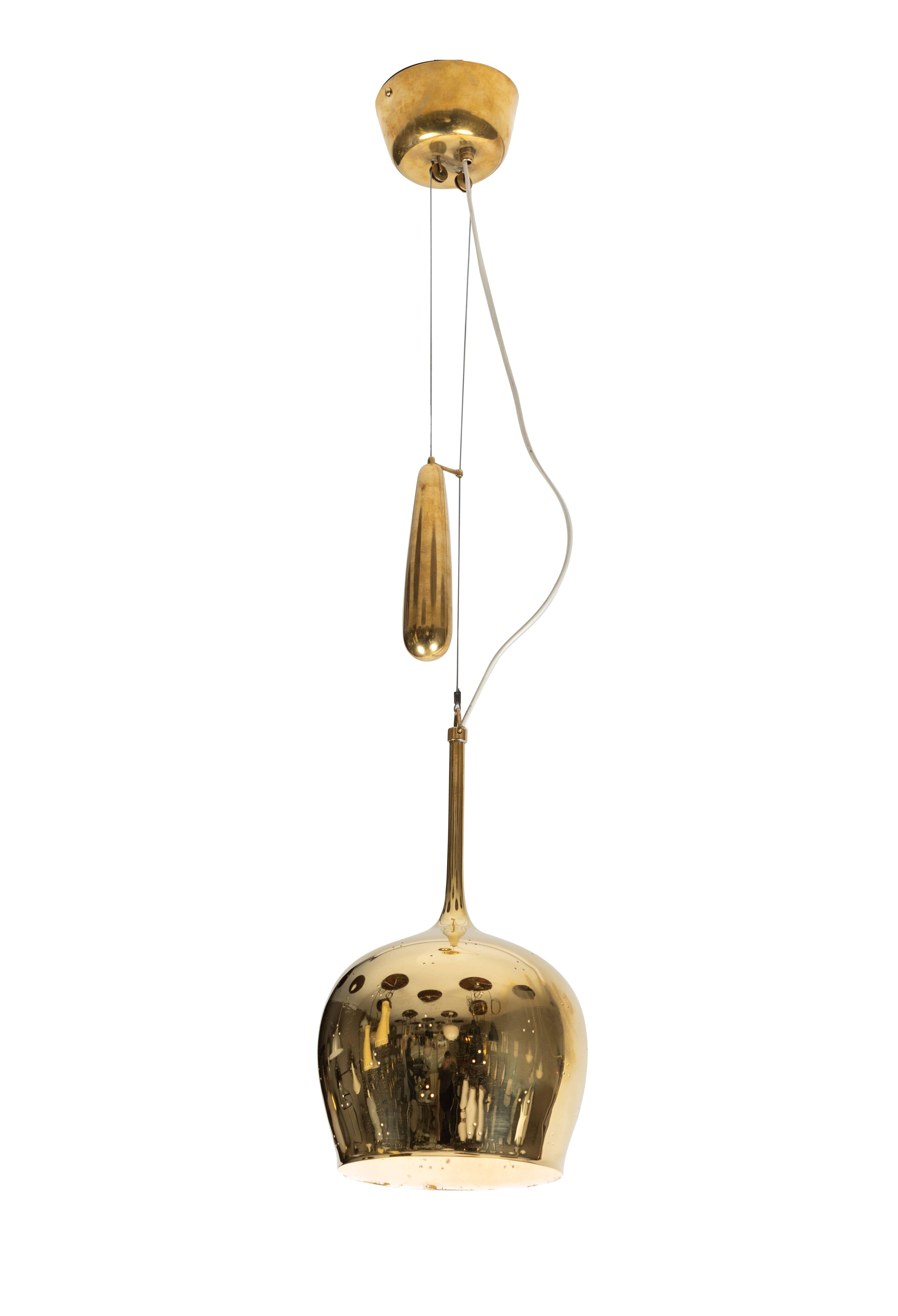 1950s Paavo Tynell A1957 counterweight pendant. This rare and exceptionally refined ceiling light is executed in brass, and can be raised and lowered using its ingenious counterweight and pulley system. Manufactured by Taito Oy in the early 1950s,