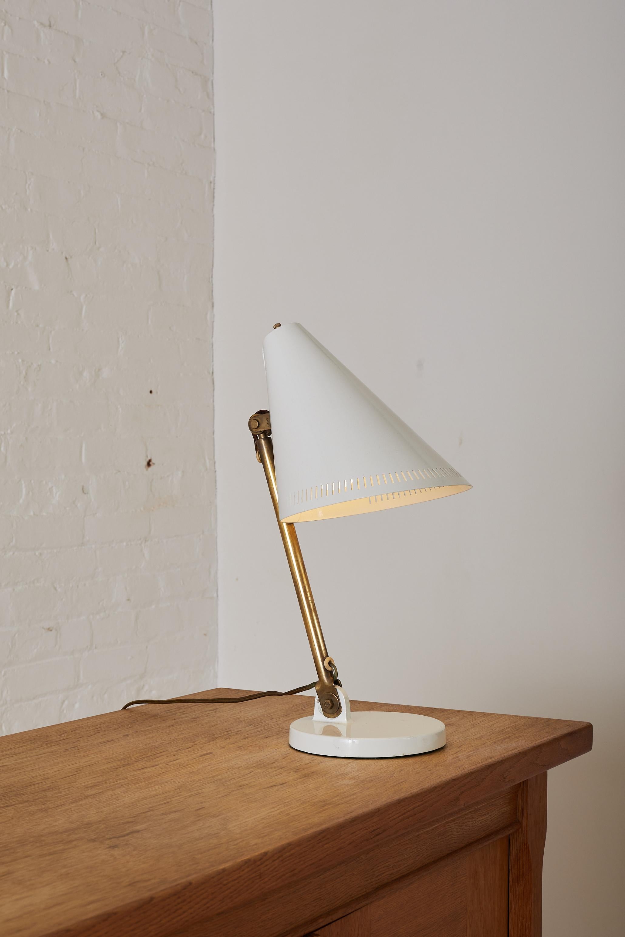 1950's Paavo Tynell for Taito Oy Desk Lamp with a white lacquered shade and brass detailing and an adjustable head. Signed 