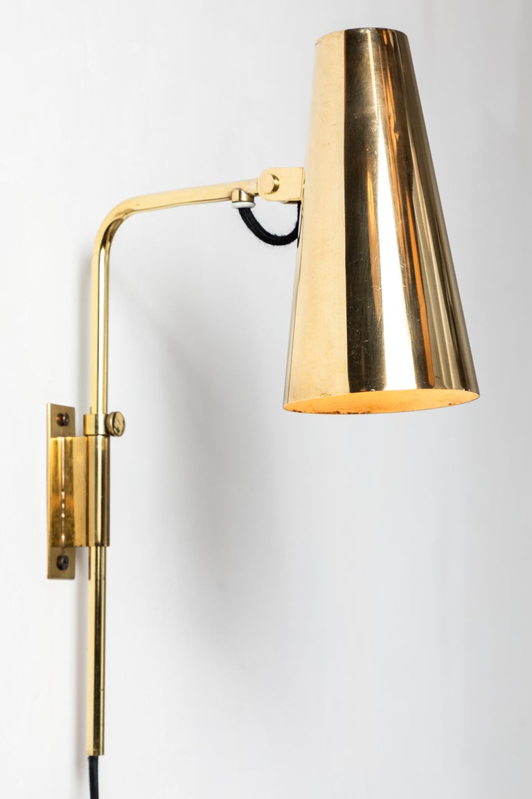 1950s Paavo Tynell 9459 wall lights for Taito Oy. These rare and exceptionally refined wall lights are executed in a rich and attractively patinated brass. Signed with impressed manufacturer's mark to shade of each example, circa 1950, Finland.