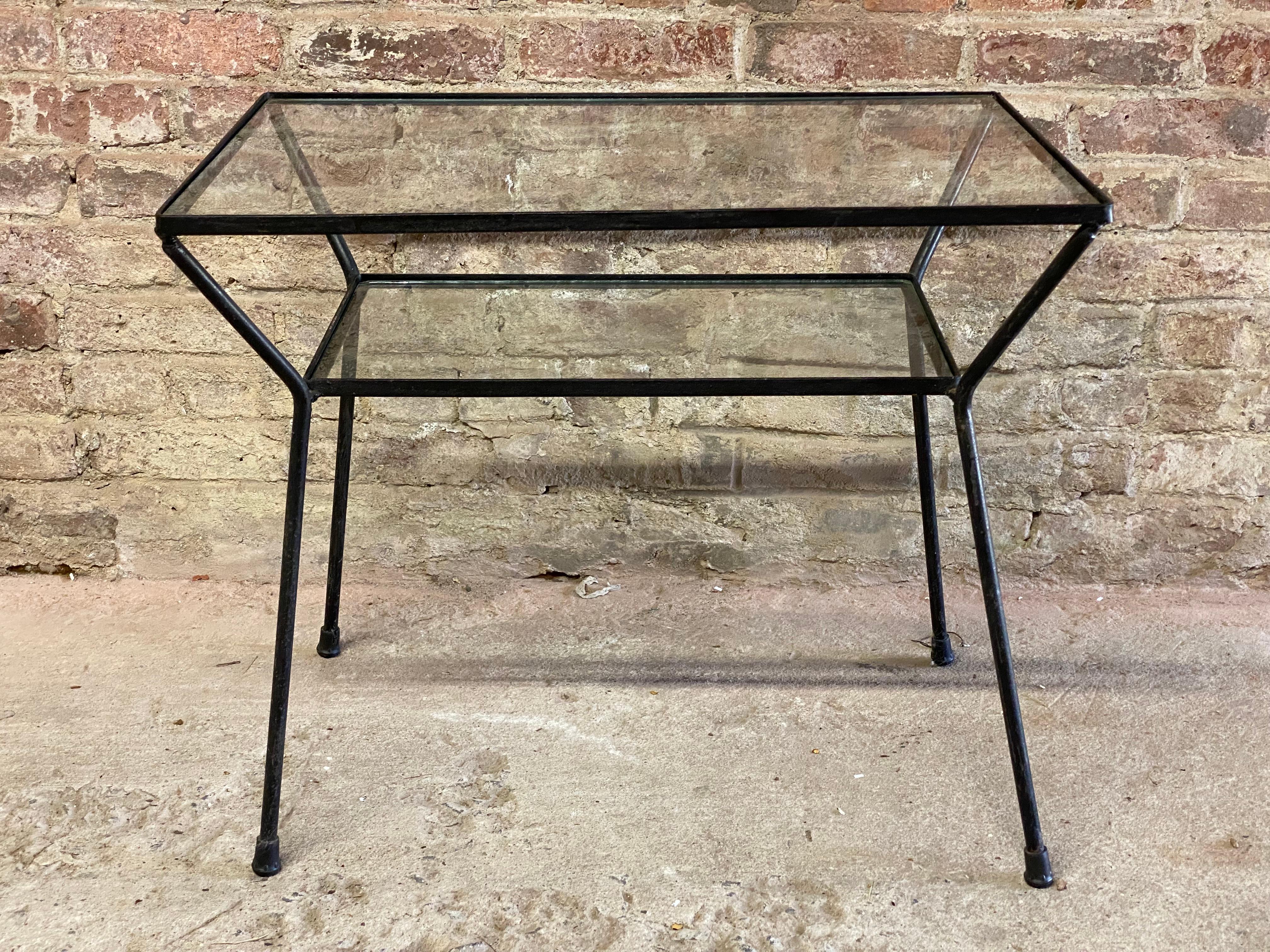 Iron frame and glass top table reminiscent of Milo Baughman for Pacific Iron Works. Featuring two glass tops with a nice flared leg frame. A nice accent table that can go just about anywhere. Circa 1950-60. Good overall condition. The glass has been