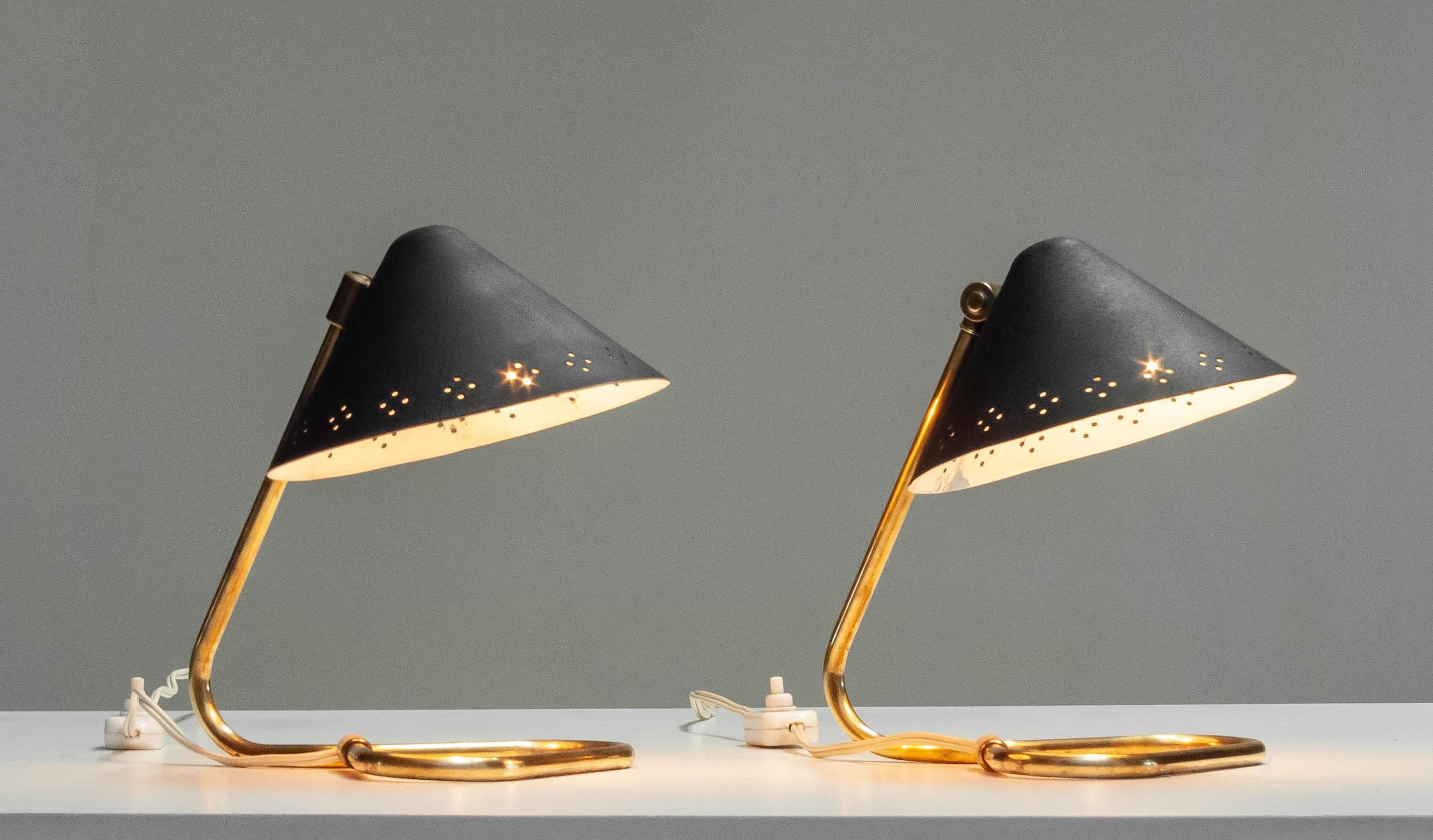 Ein Paar Erik Warna 'GK14' Tischlampen aus den 1950er Jahren mit schwarzem und messingfarbenem perforiertem Schirm. 
Die Schirme sind nach oben oder unten verstellbar. Produziert von Gnosjö Konstsmide Rydahls in den 1950er Jahren in Schweden.
Alle