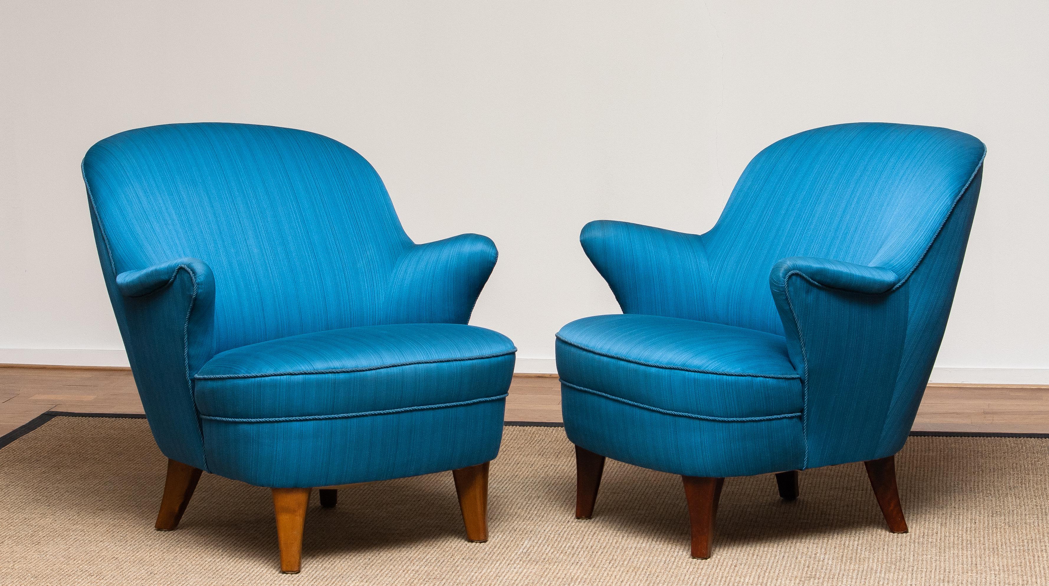 Beautiful and very comfortable set of two Scandinavian easy / lounge / club chairs in petrol colored fabric in the manner of Kurt Olsen.
Both are in good condition!