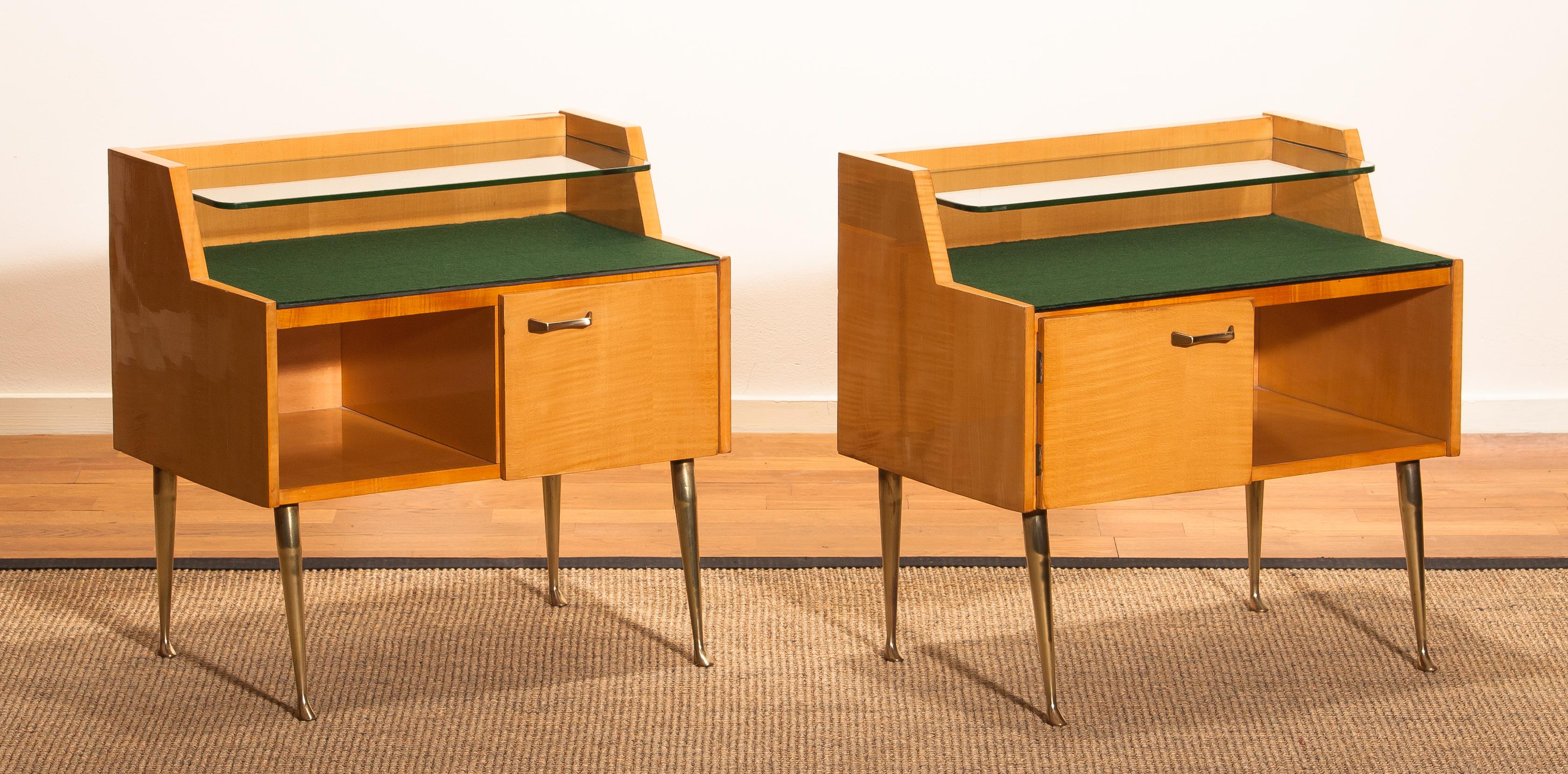 Beautiful set of two Italian midcentury bedside tables in maple with brass legs and brass handle designed by Paolo Buffa, Italy, 1950s.
Both are in good condition.
The top is covered with green felt and In addition, there's a smaller glass shelf