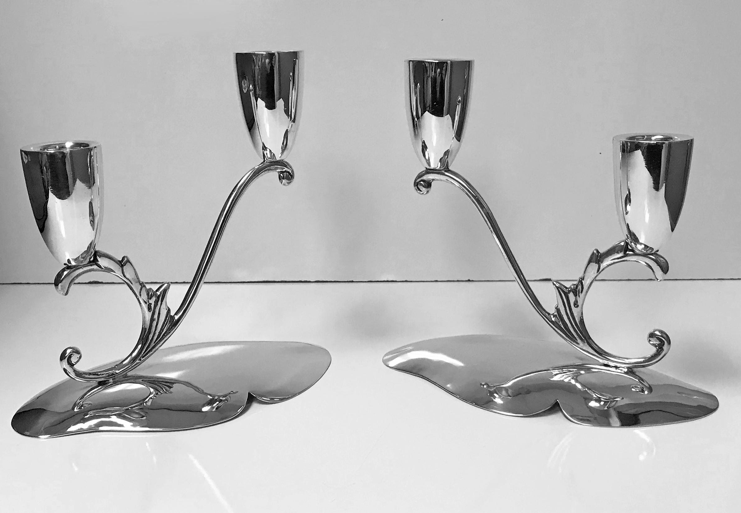 1950s pair of midcentury Mexican sterling silver two-light candelabra candlesticks Juventino Lopez Reyes. The candelabra of stylized scroll form, in each with two plain, tulip shaped capitals. All surmounted on a slightly convex scalloped plain