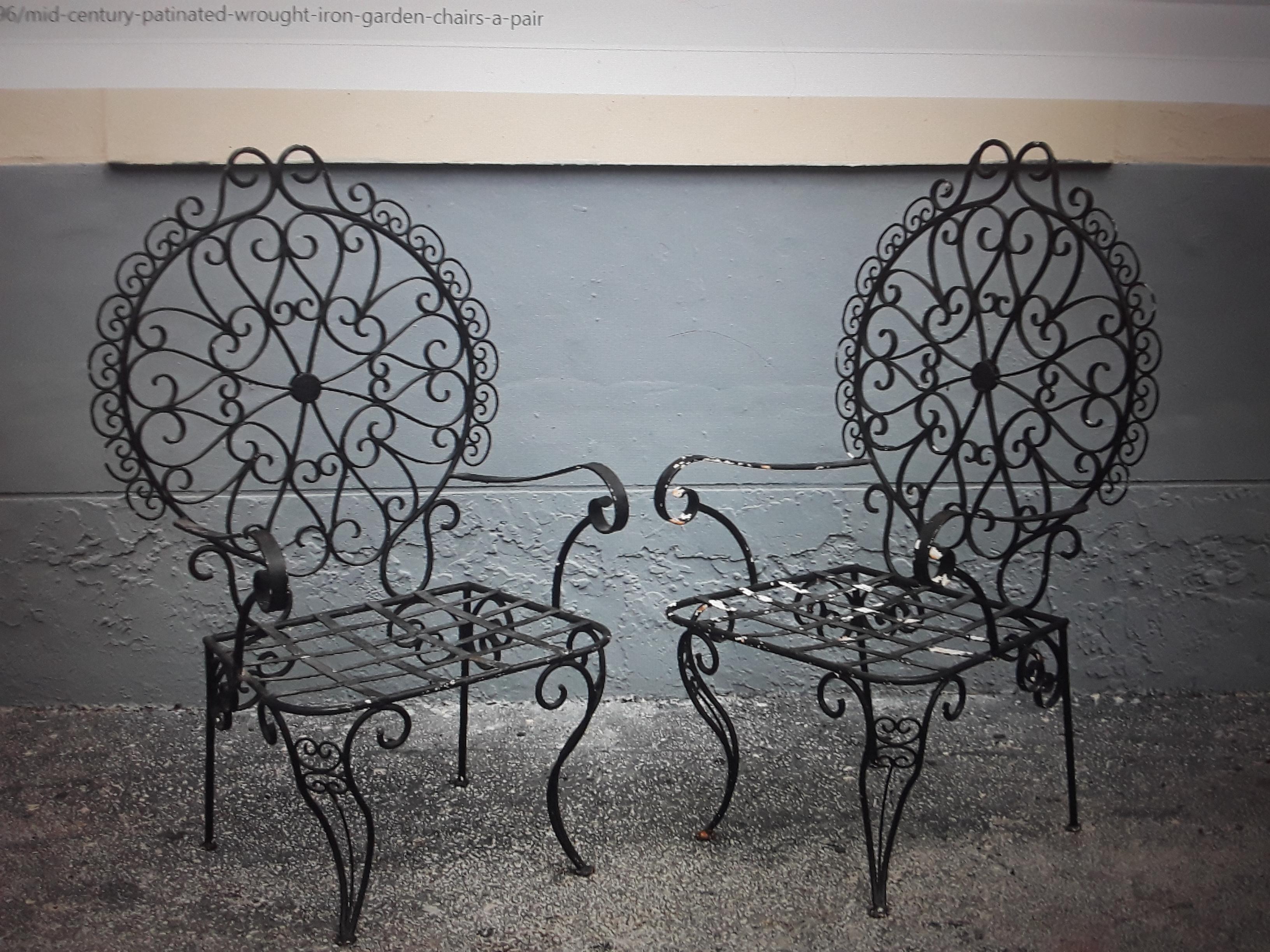 Pair 1950's Mid Century Wrought Iron Garden Chairs. Patinated Black, worn paint mostly on one chair. Lovely set which could be used on the porch, in the garden, many places.