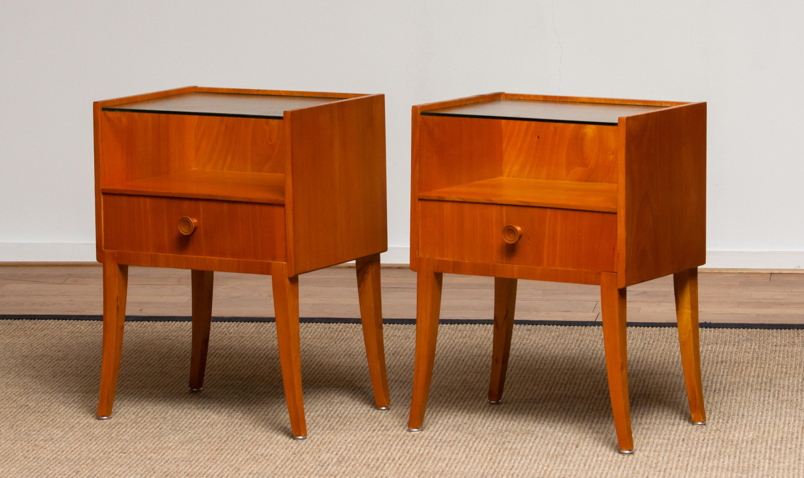 Very elegant set of two Scandinavian nightstands / bedside tables made in Elm with a glass toping from Sweden.
The night stands / bedside tables are overall in good condition.