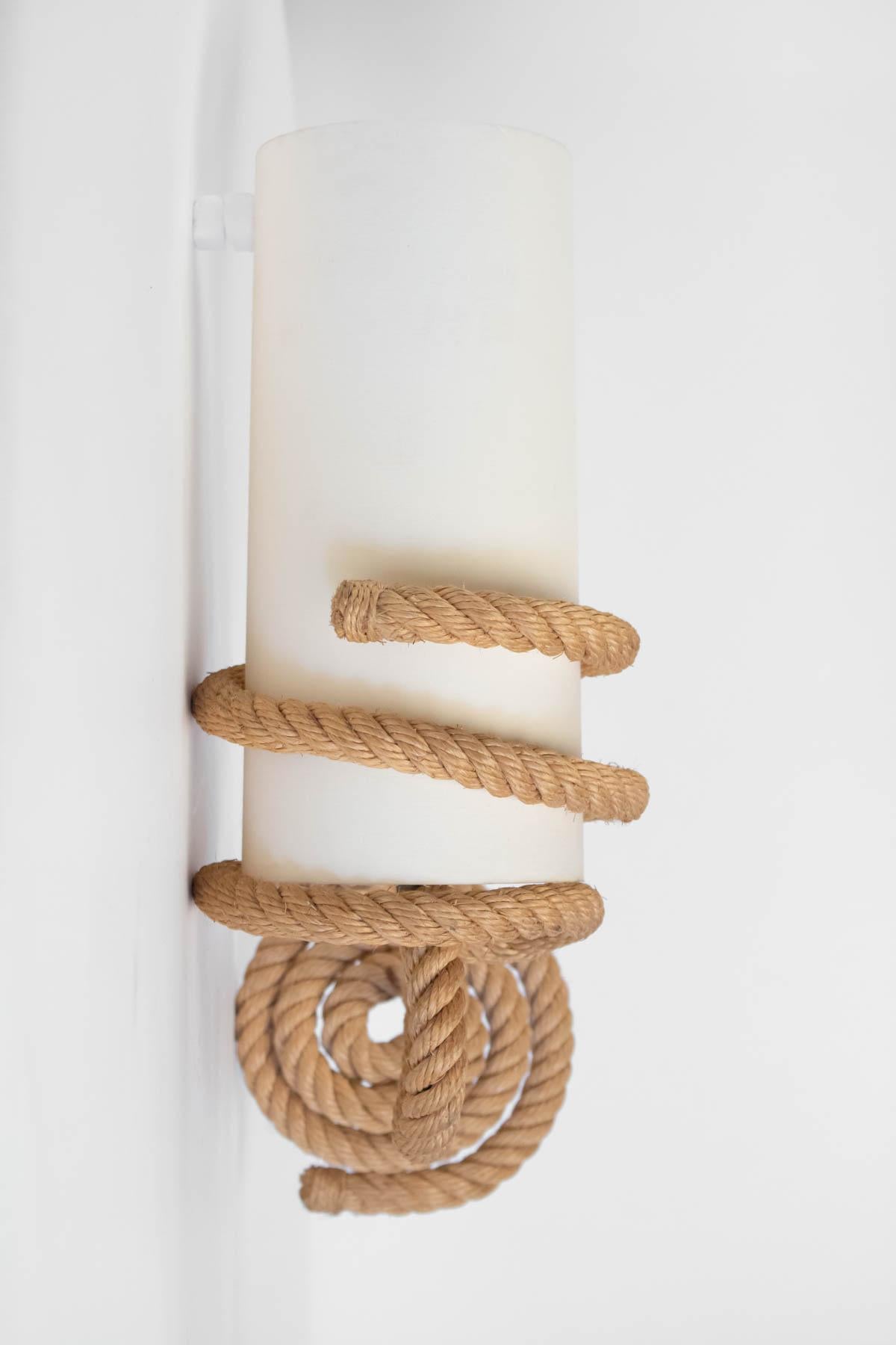 The sconces are made of weaved rope. 
The two cylindrical white cotton shades are hold by a rope spiral.
One bulb per sconce.

Adrien Audoux and Frida Minet are known for their rope lights and furniture. Their first workshop has been founded in 1929