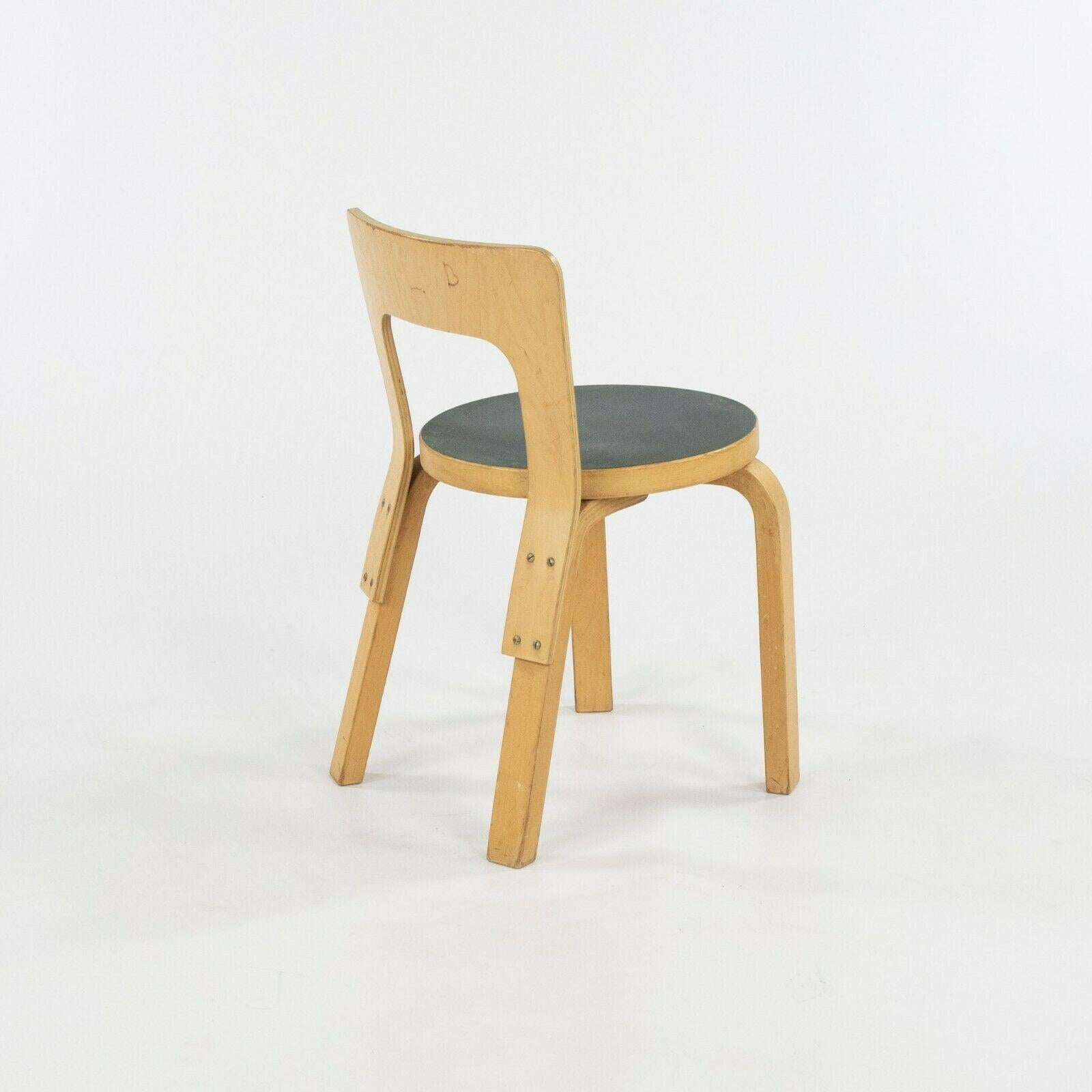 Listed for sale is a pair of circa 1950s N65 childs chairs designed by Alvar and Aino Aalto, produced by Artek in Finland. These chairs were ordered with blue/green laminate seats and birch plywood construction. They are vintage examples with signs