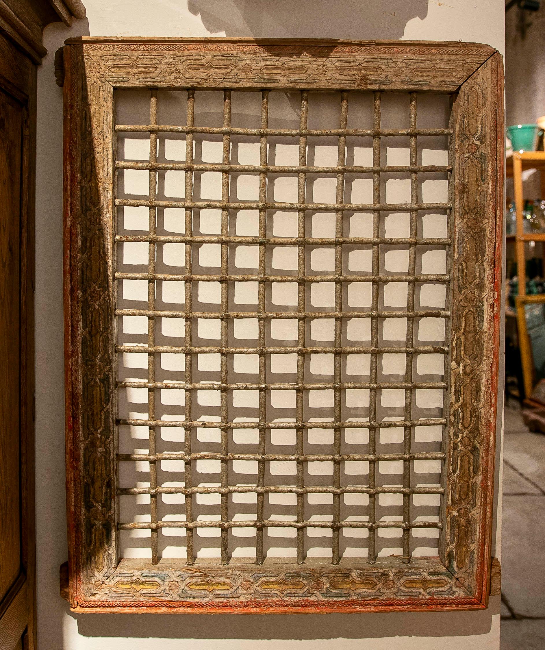 A magnificent pair of antique Moroccan decorative grilles, crafted from carved wood and retaining traces of their original polychromy in reddish and golden tones. The pieces display a geometric latticework of rods that adds texture, visual rhythm,