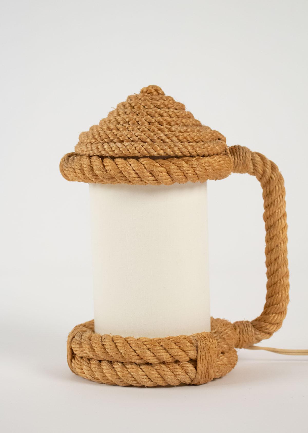 Pair of rope table lanterns.
Composed of a rope base on which a rising handle leaves and dressed in a rope hat opening like a beer mug.
In the middle is placed a cylindrical lampshade in off-white cotton matching the originals.
One bulb per