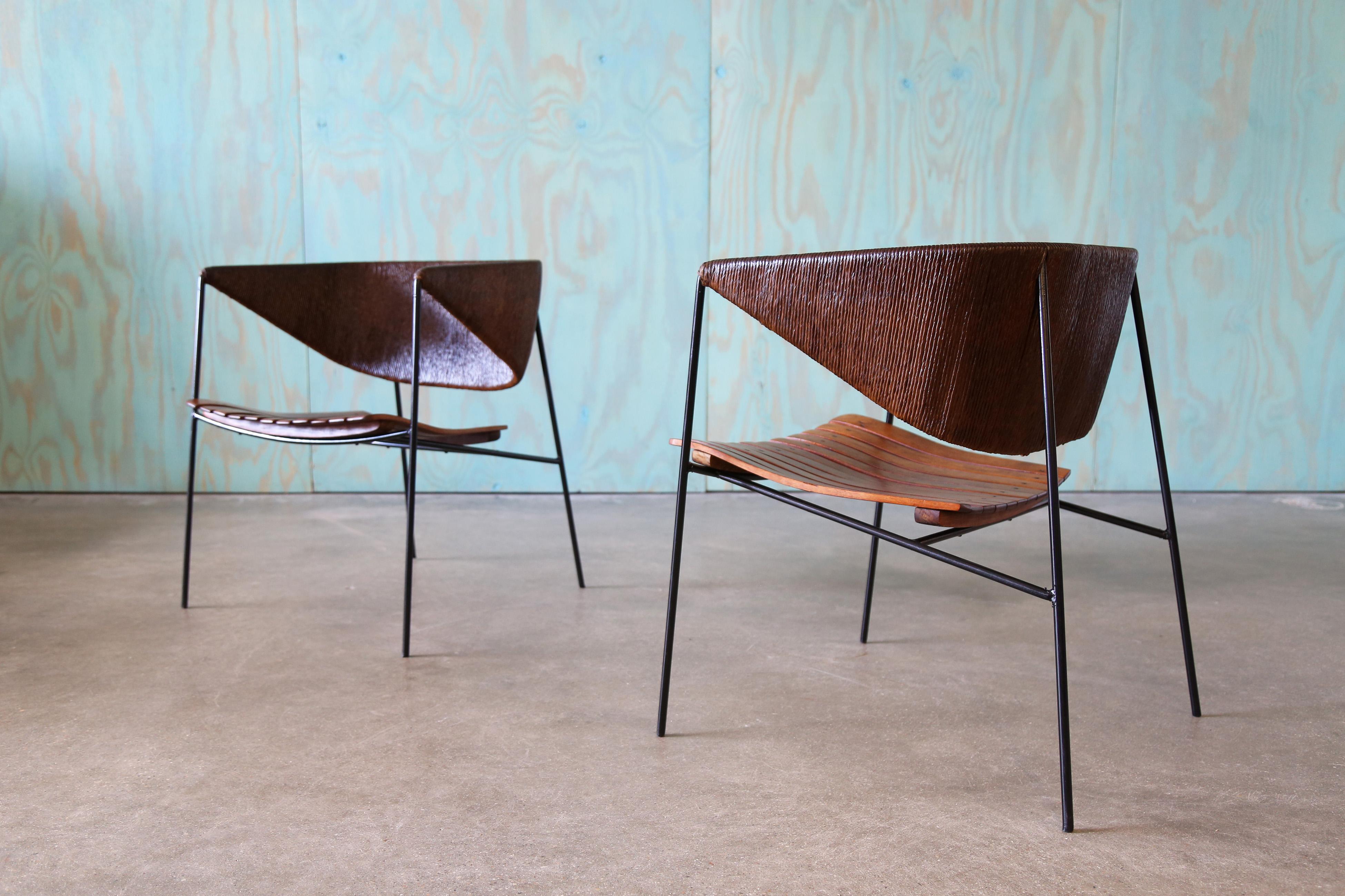 Un diseño único y muy coleccionable de Arthur Umanoff para Raymor. Estos sillones de salón de los años 50 combinan armazones de hierro minimalistas, listones de roble clásicos y un respaldo exagerado, envuelto en cuerda de papel.  Los ángulos duros