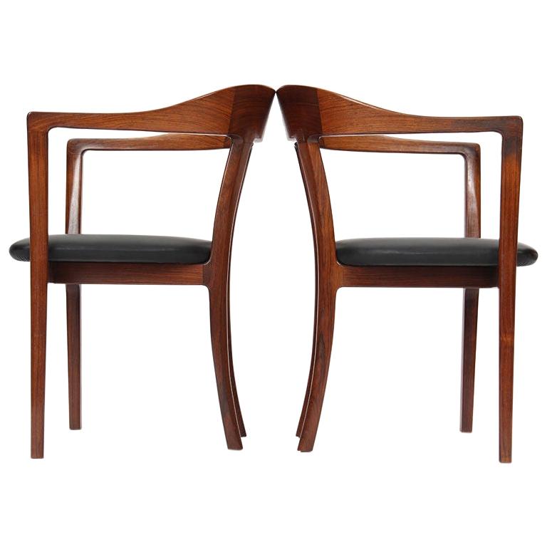 A pair of rosewood hump back arm chairs with black leather upholstery. Designed by Ole Wanscher and Manufactured in 1958 by A.J. Iversen. Fully restored by the Wyeth Workshop.