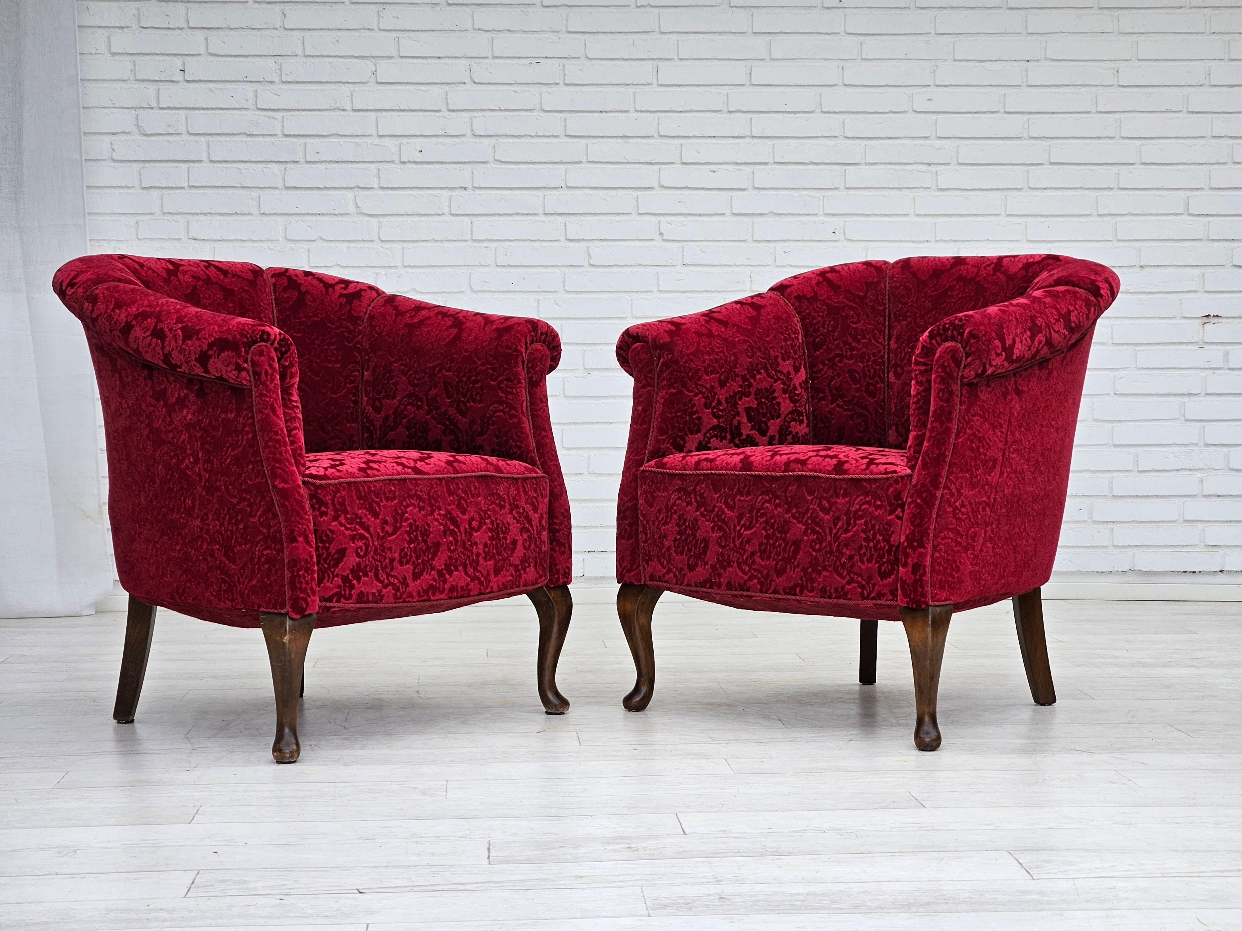 1950s, pair of Danish lounge chairs. Reupholstered about 20 years ago by craftsman in Denmark. Very good condition: no smells and no stains. Red cotton/wool fabric, beech wood legs, brass springs in the seat. Manufactured by Danish furniture