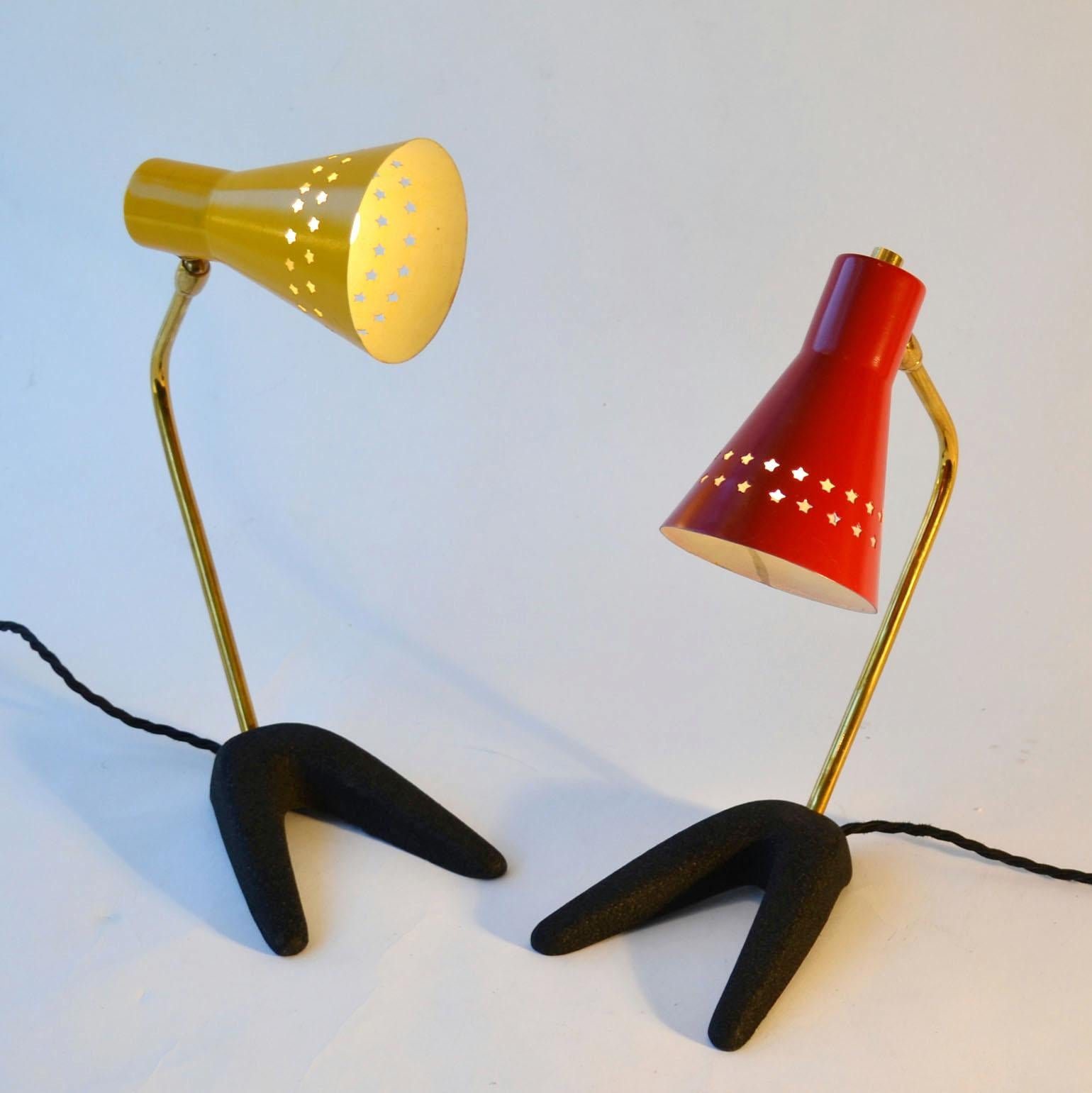 Pair of small table or bedside lamps on crow-feet, one with red and one yellow adjustable metal shade perforated with star-shapes and articulated brass arms. They are attributed to Jean Boris Lacroix, France.
The shades are in their original colour