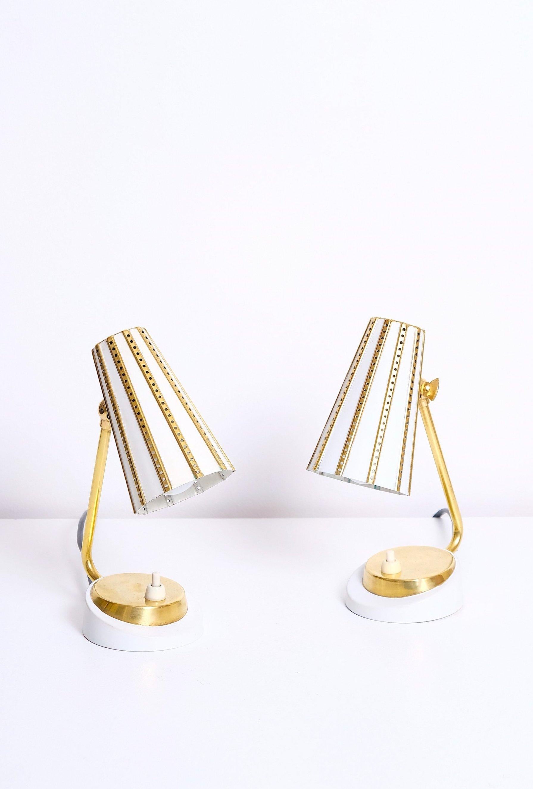 Pair of brass nightstand lamps manufactured in Germany in the 1950’s. Lacquered brass body, perforated lacquered brass shades. 40-60 watt E-14 (European bulb) or higher if LED/CFL.
Verified original E-14 sockets, 20/2 plastic cord, push button