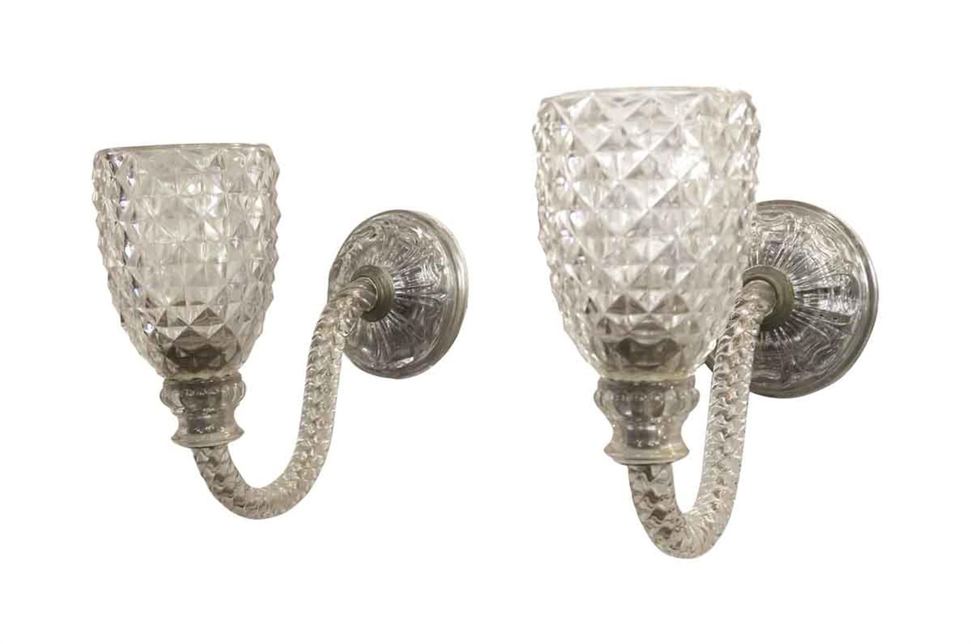 Clear blown and cut single arm glass sconces. Italian made in the 1950s. Priced as a pair. This can be seen at our 2420 Broadway location on the upper west side in Manhattan.