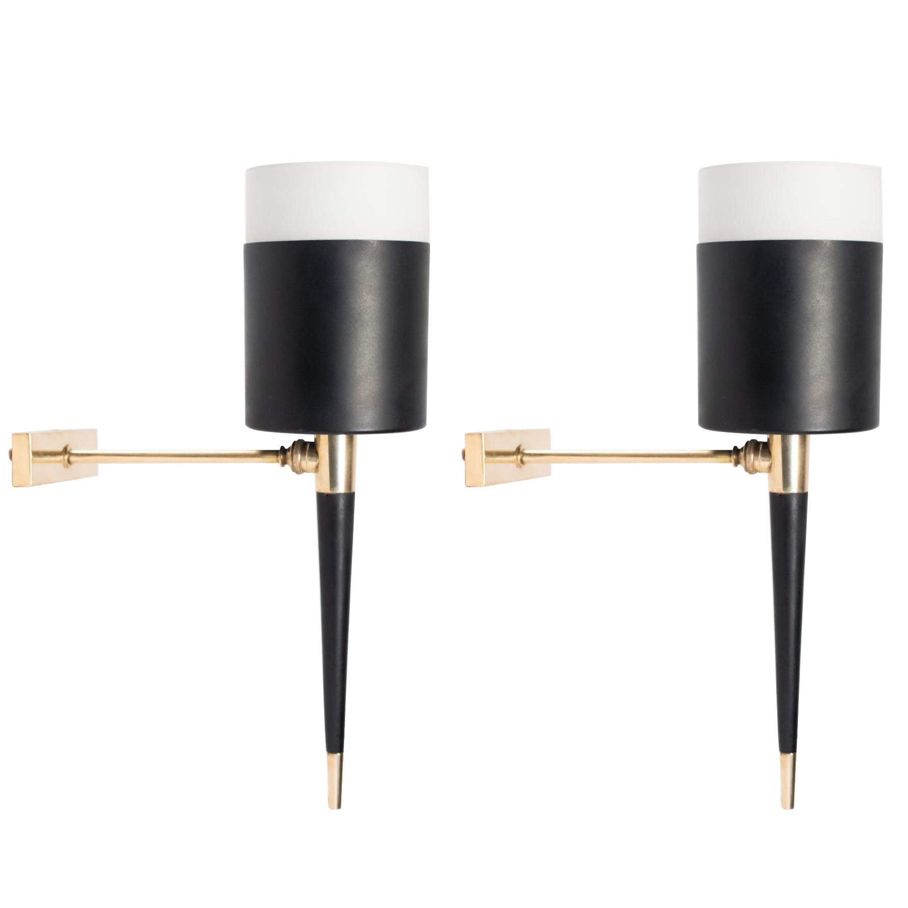 Shaped in torch with a brass back plate and a brass arm.
The stem is made of black lacquered wood with a brass spike.
The diffusor consist cylindrical metal cup blackened with white glass satin shade.

One bulb per sconce.
Four sconces