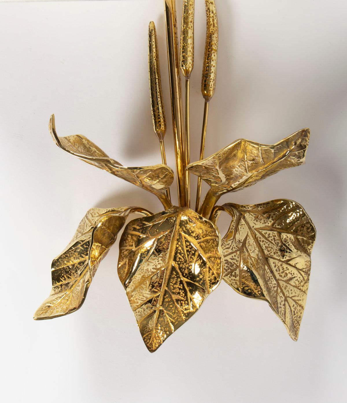 1950s pair of Maison Charles foliage bronze sconces.

The sconce body made of gilded bronze figures four leaves with three stylized flowers. The off-white cotton lamp shades are mounted on a brass stem.

One bulb per sconces.
       
