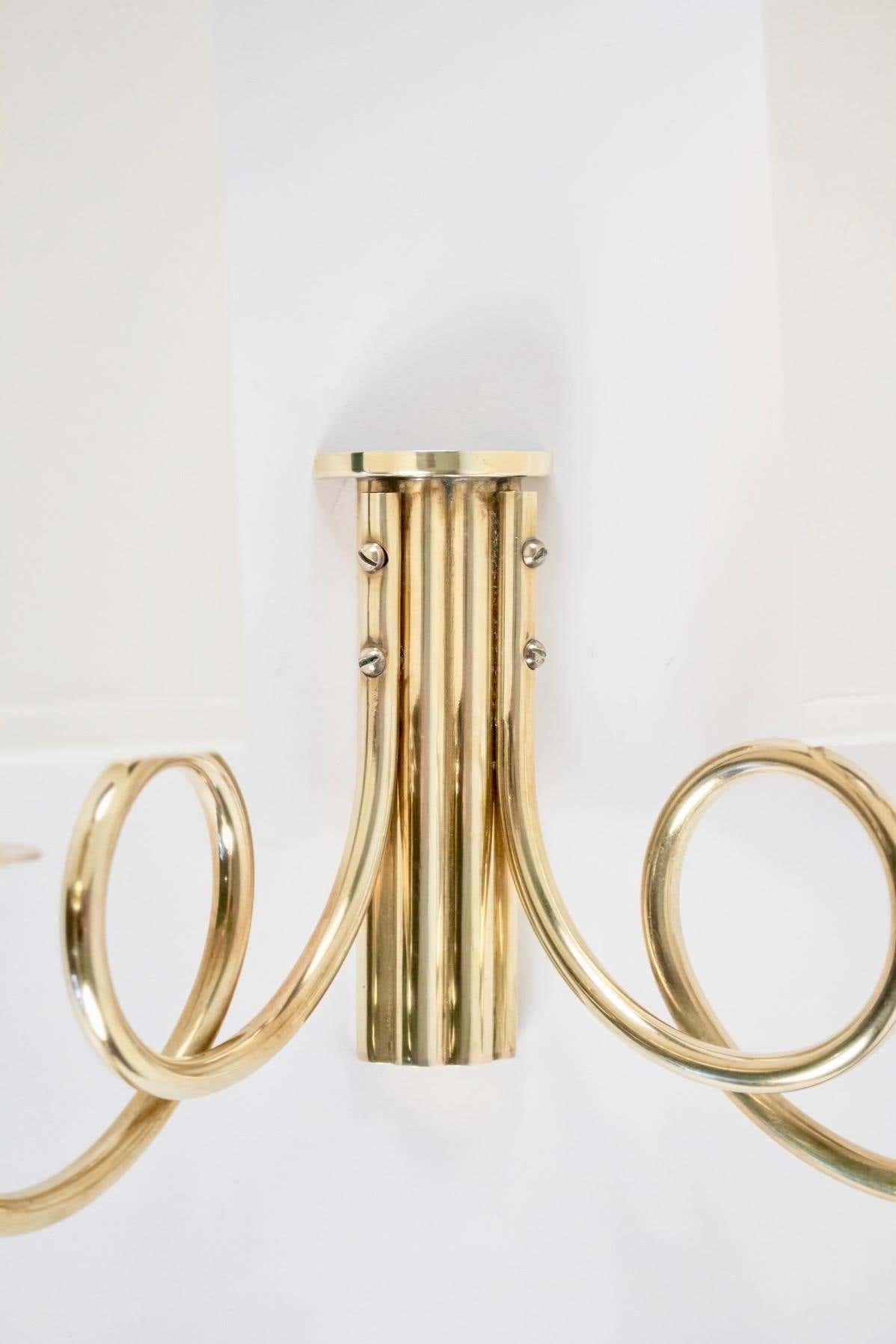 Pair of Maison Lunel wall lights from the 1950s,

Composed of a large wall plate in gilded brass on which are positioned two sconces formed by two rising rods, they are dressed in satin opal glass.
A small blackened brass plaque placed on the