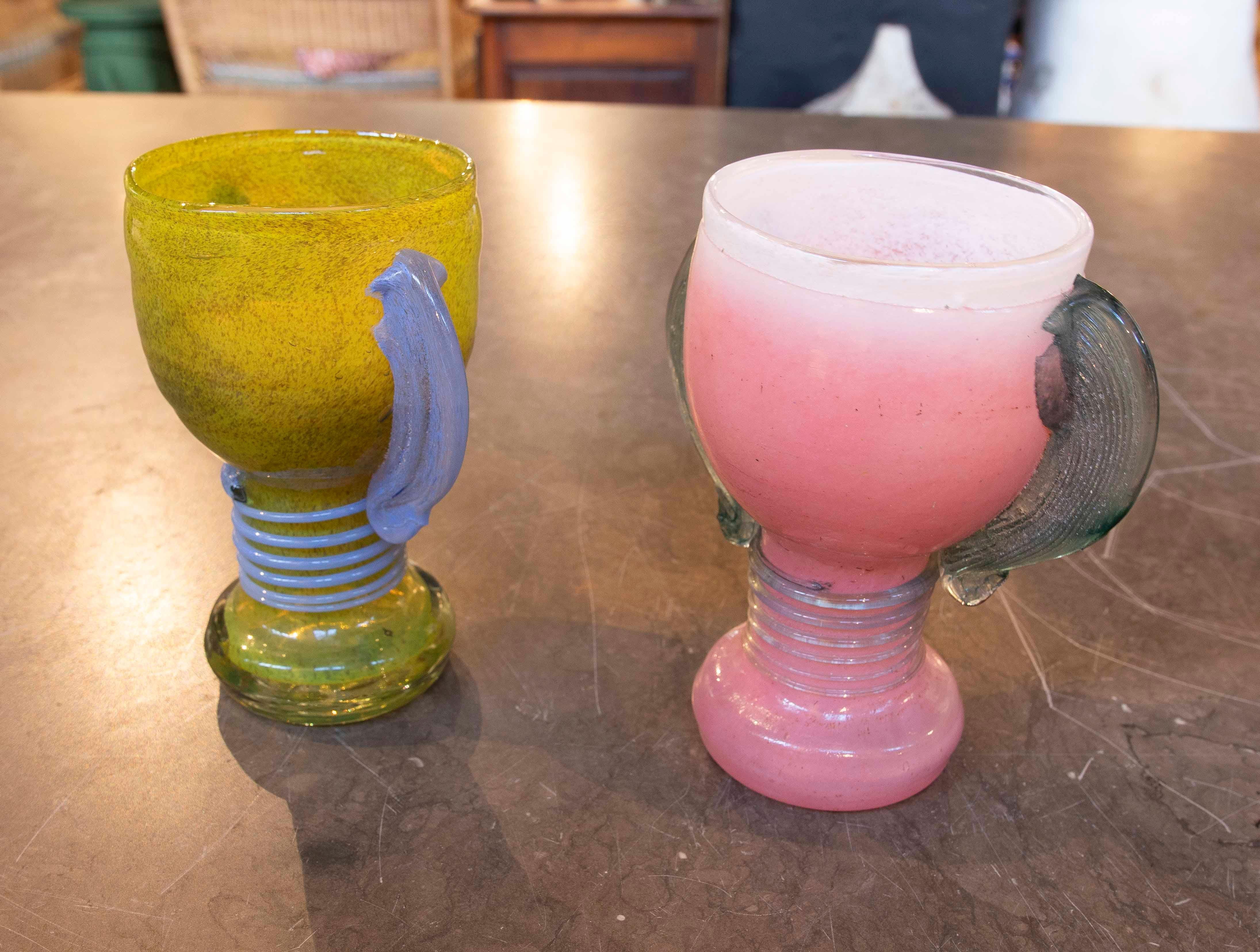 Paire de gobelets en verre soufflé à la main de Murano avec anses latérales en jaune, bleu et rose.