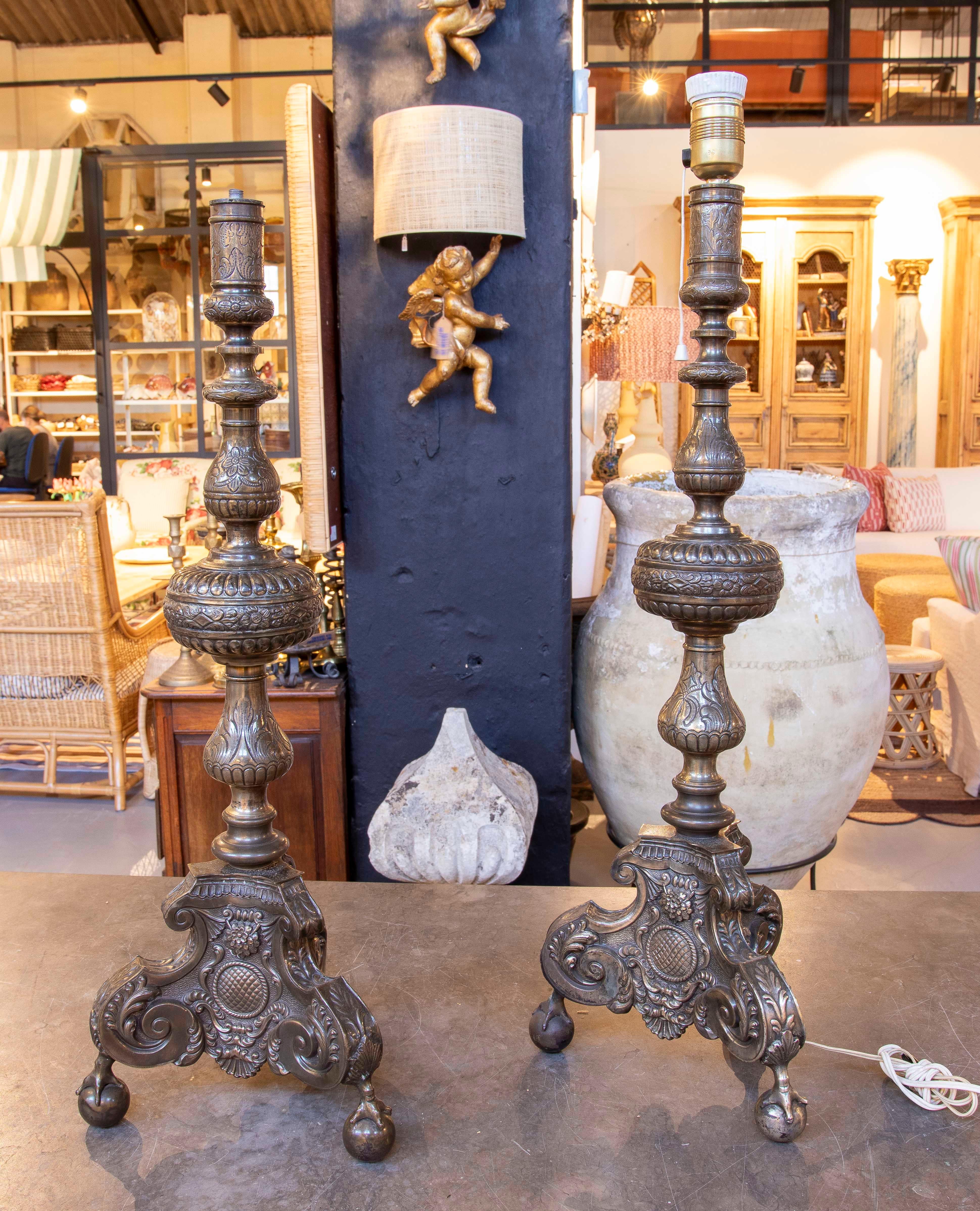 Pareja de candeleros de metal plateado de los años 50 con trabajo en relieve y patas en forma de garra en Bueno estado para la venta en Marbella, ES