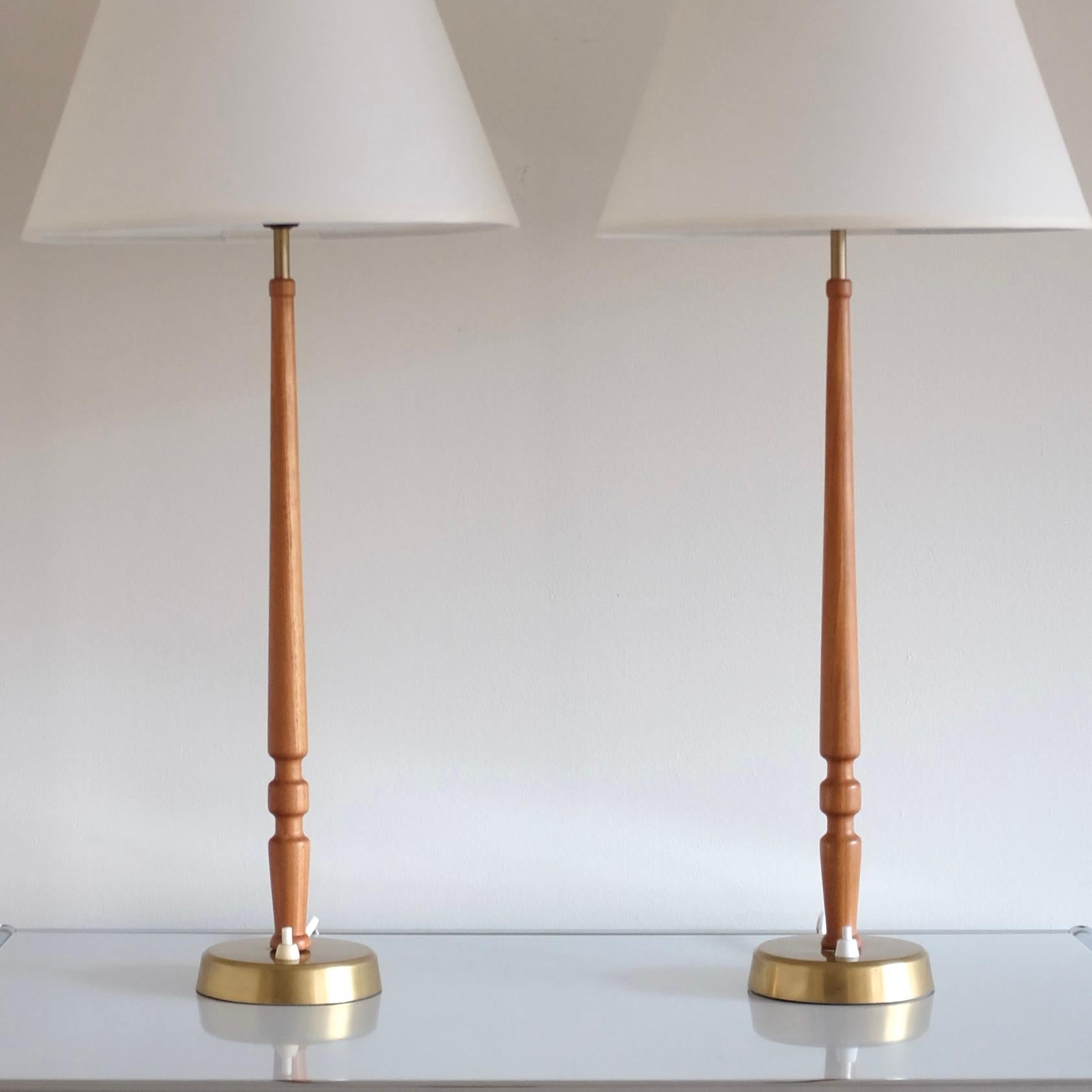 Años 50 Pareja de lámparas de mesa modelo 743 de Hans Bergström para Ateljé Lyktan, Suecia. Brazos de lámpara de madera de teca bellamente tallados, con un fetón de latón y una pantalla de lino nueva. En general, muy buen estado vintage. Viene con
