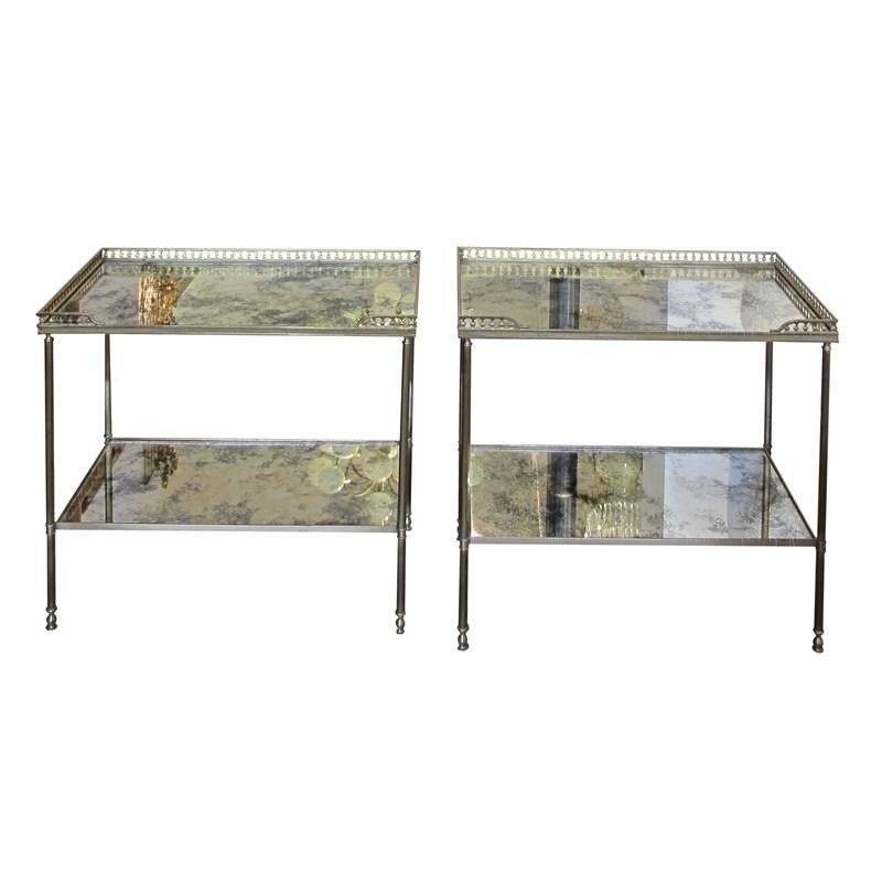 Ein elegantes Paar französischer, zweistöckiger Beistelltische aus Messing von Maison Bagues aus den 1950er Jahren. Jeder Tisch hat eine rechteckige Platte und eine untere Ablage mit antikisierten Spiegeln, die den Charme der Tische im Vintage-Stil