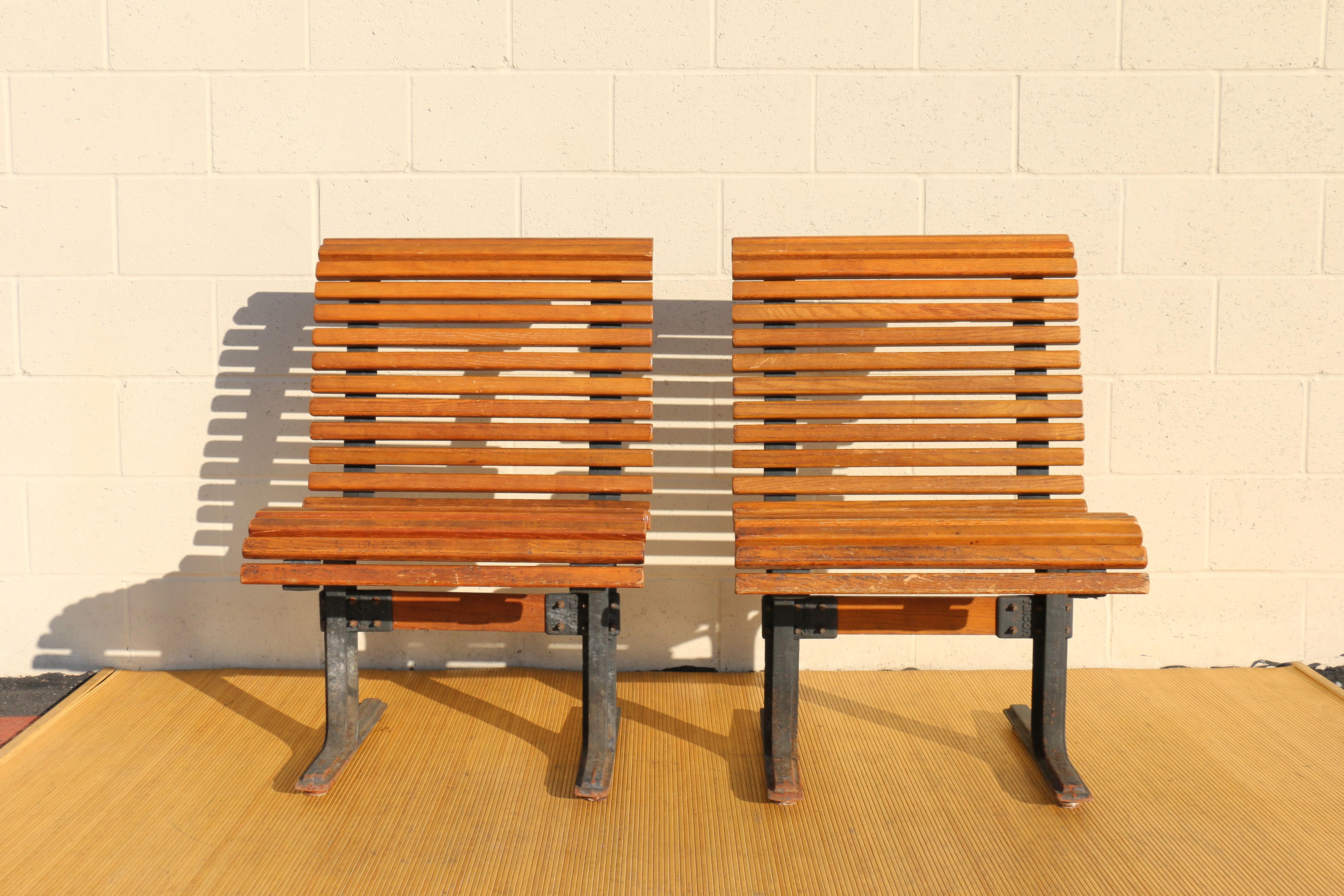 Spectacular pair of vintage chairs both have heavy cast iron frames with solid oak slats attached. The cast has Manufactures name impressed in each leg. It can be placed together and make a long bench. Each of 23 oak slats are attached to the frame