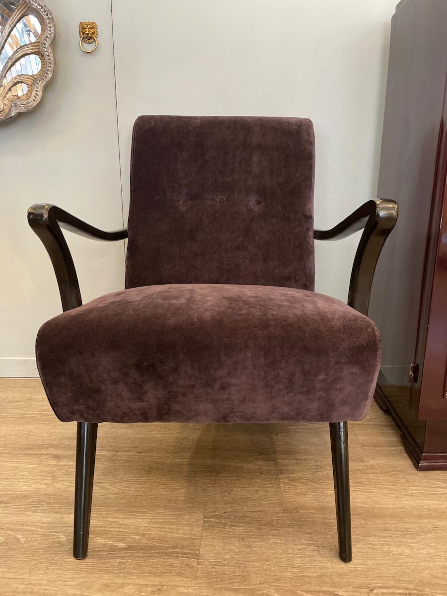 Pair of 1950s armchairs with a black lacquered wooden frame. The wood has a very elegant shape, with curved armrests at the front and sides, and slender legs that give the seat a light and graceful appearance. The armchairs have been reupholstered