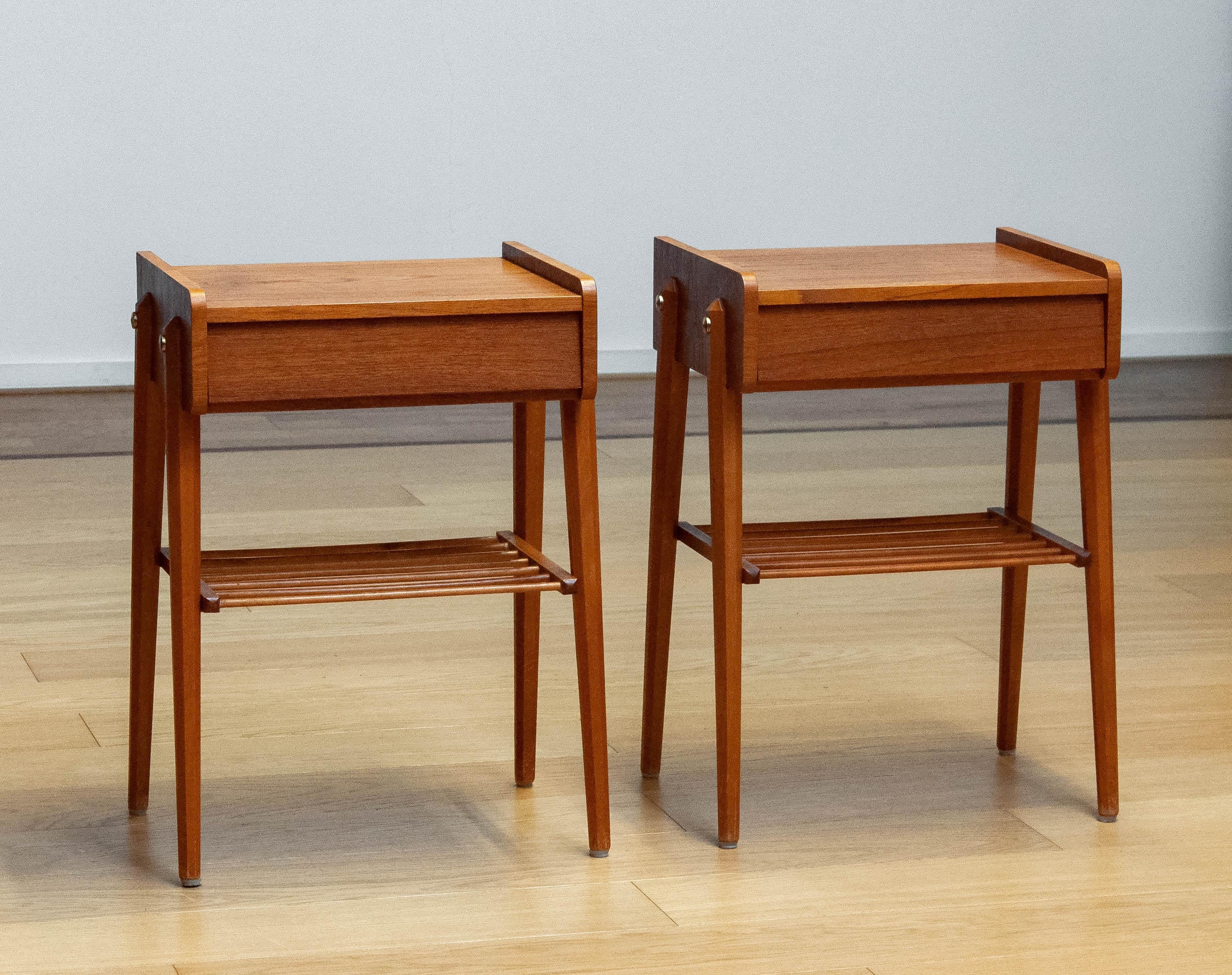 Scandinavian modern teak nightstands from the mid 20th century. The pair are designed and made in Sweden and have a single large drawer as well as a ribbed shelf. A decorative detail is the brass hardware. Marked AB BJÄRNI Bjärnum which is a Swedish